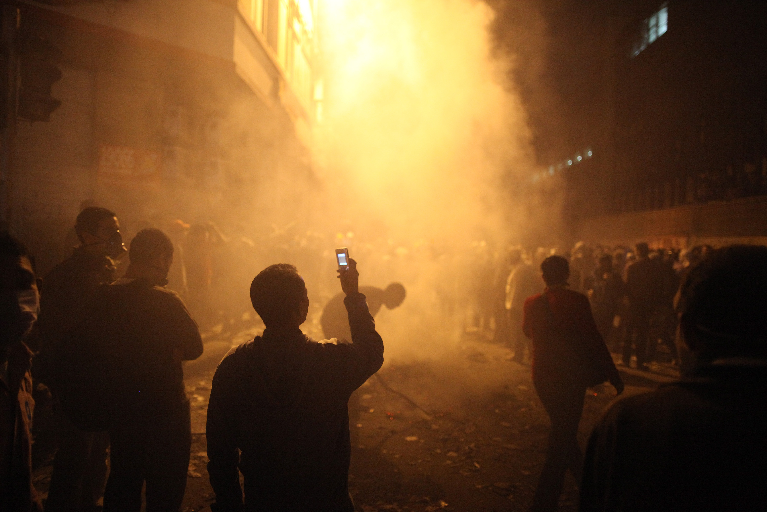 A youth films the aftermath of tear gas police fired at protestors in Muhammed Mahmoud Street near Tahrir Square on November 23 in Cairo.