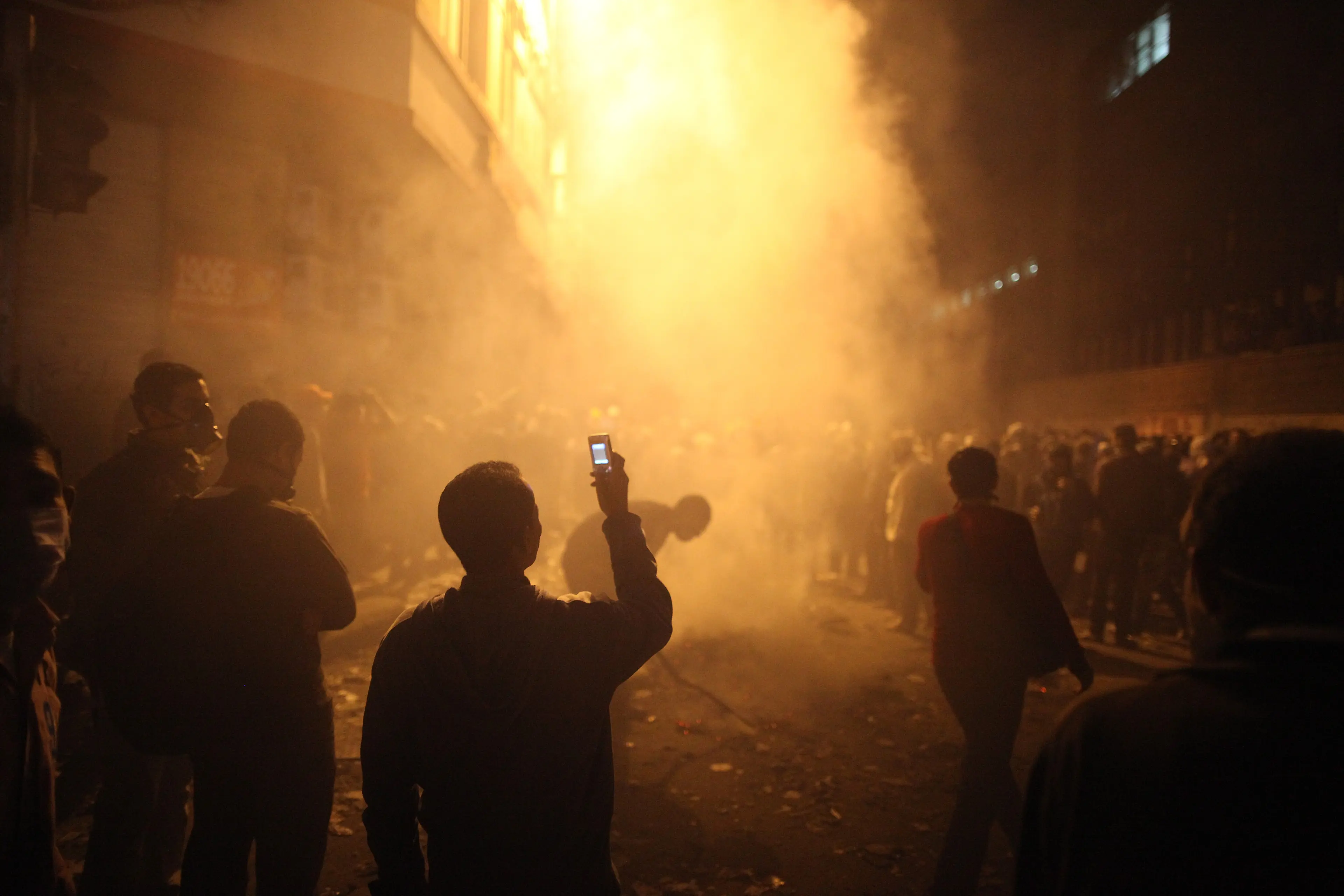A youth films the aftermath of tear gas police fired at protestors in Muhammed Mahmoud Street near Tahrir Square on November 23 in Cairo.