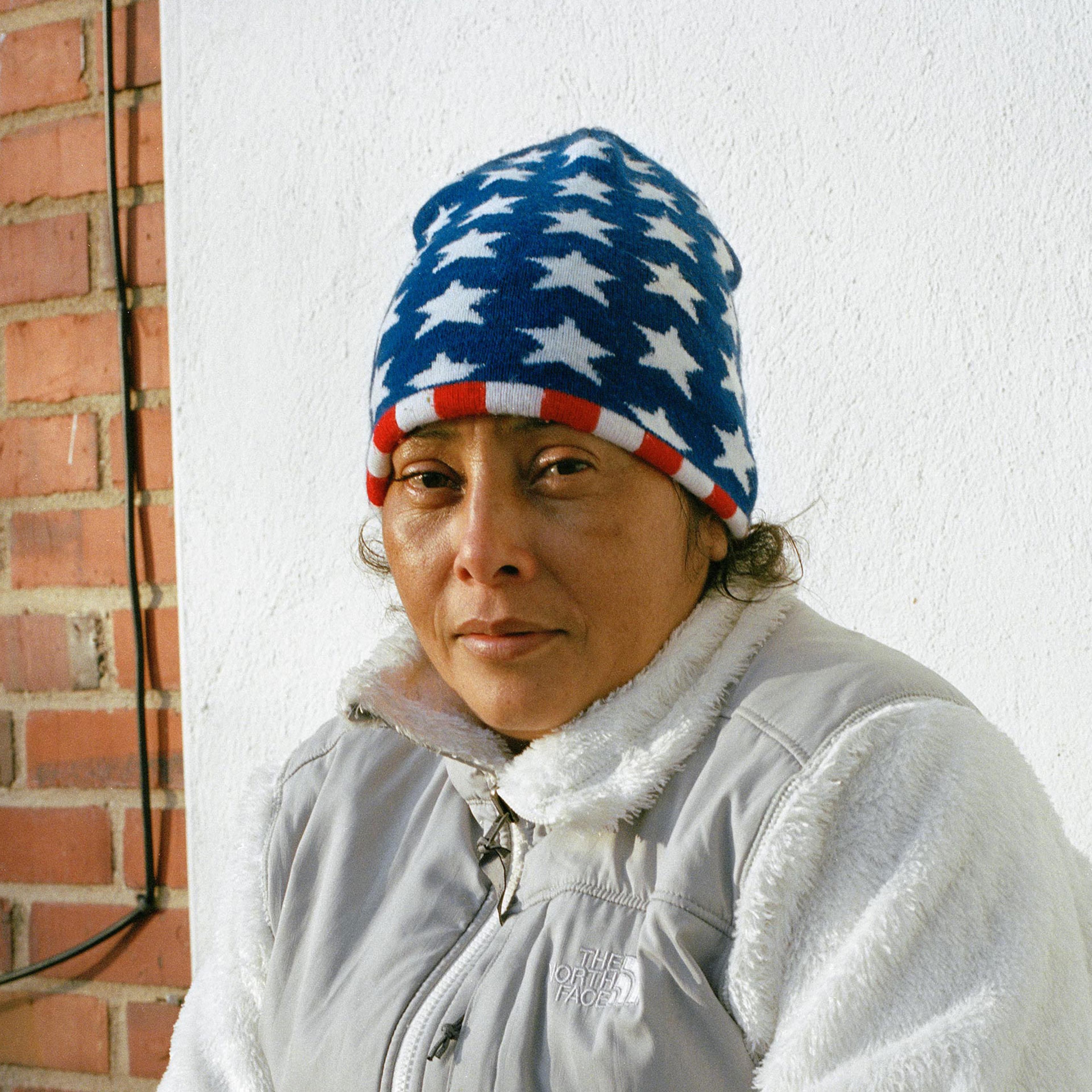 Maria Lidia Meza Castro, 40, sits in front of her new house on March 7. For the past four months, Castro and her children have been living in a house in the suburbs of Washington, D.C. while her attorneys gather all the documentation necessary for her as