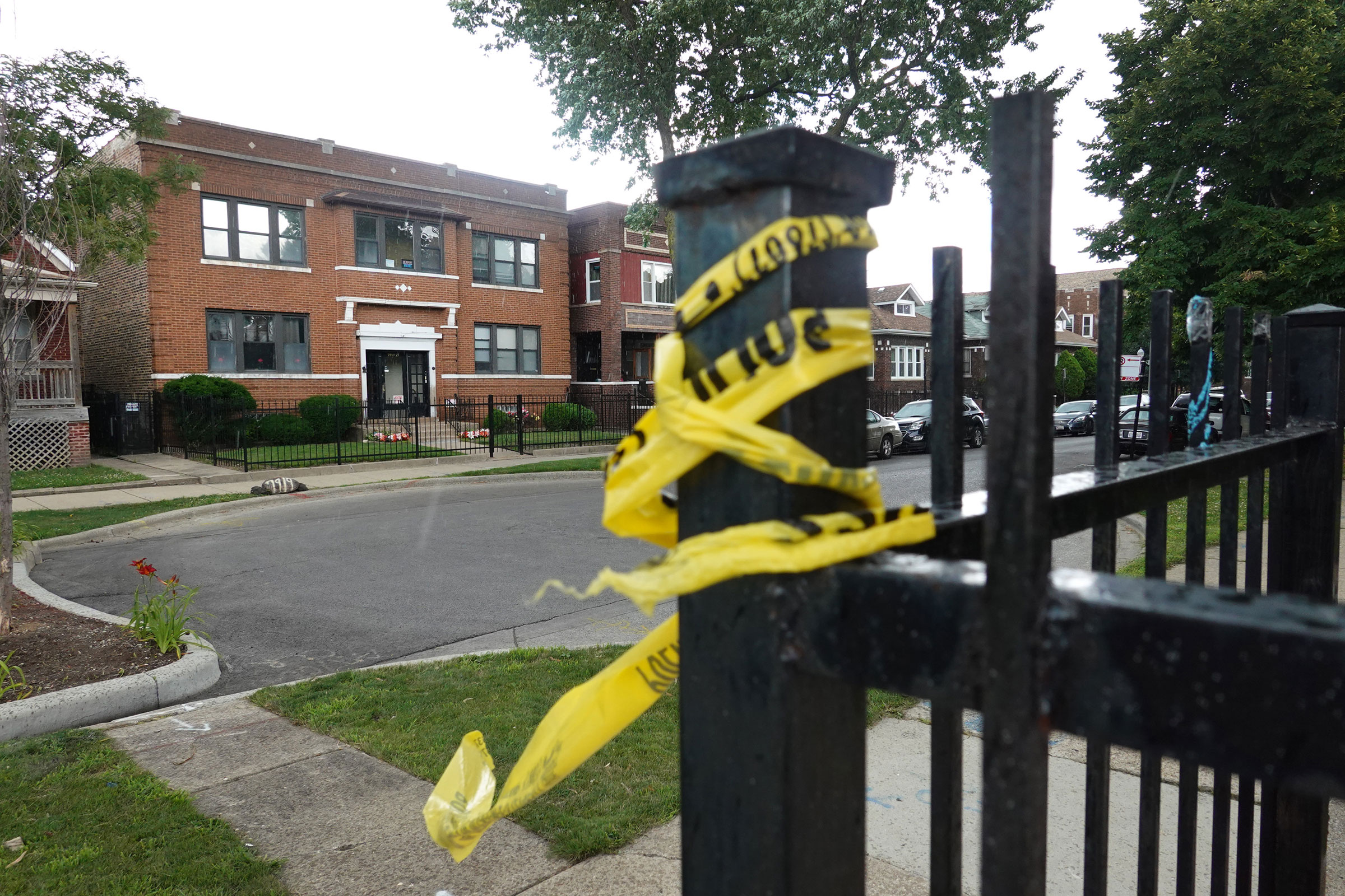 Crime scene tape remains on a fence near the Rhodes funeral home in the Auburn Gresham neighborhood, where at least 15 people were shot during a funeral, in Chicago on July 22, 2020.