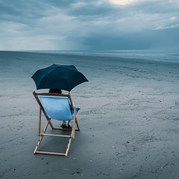woman-sitting-beach-dark-sky