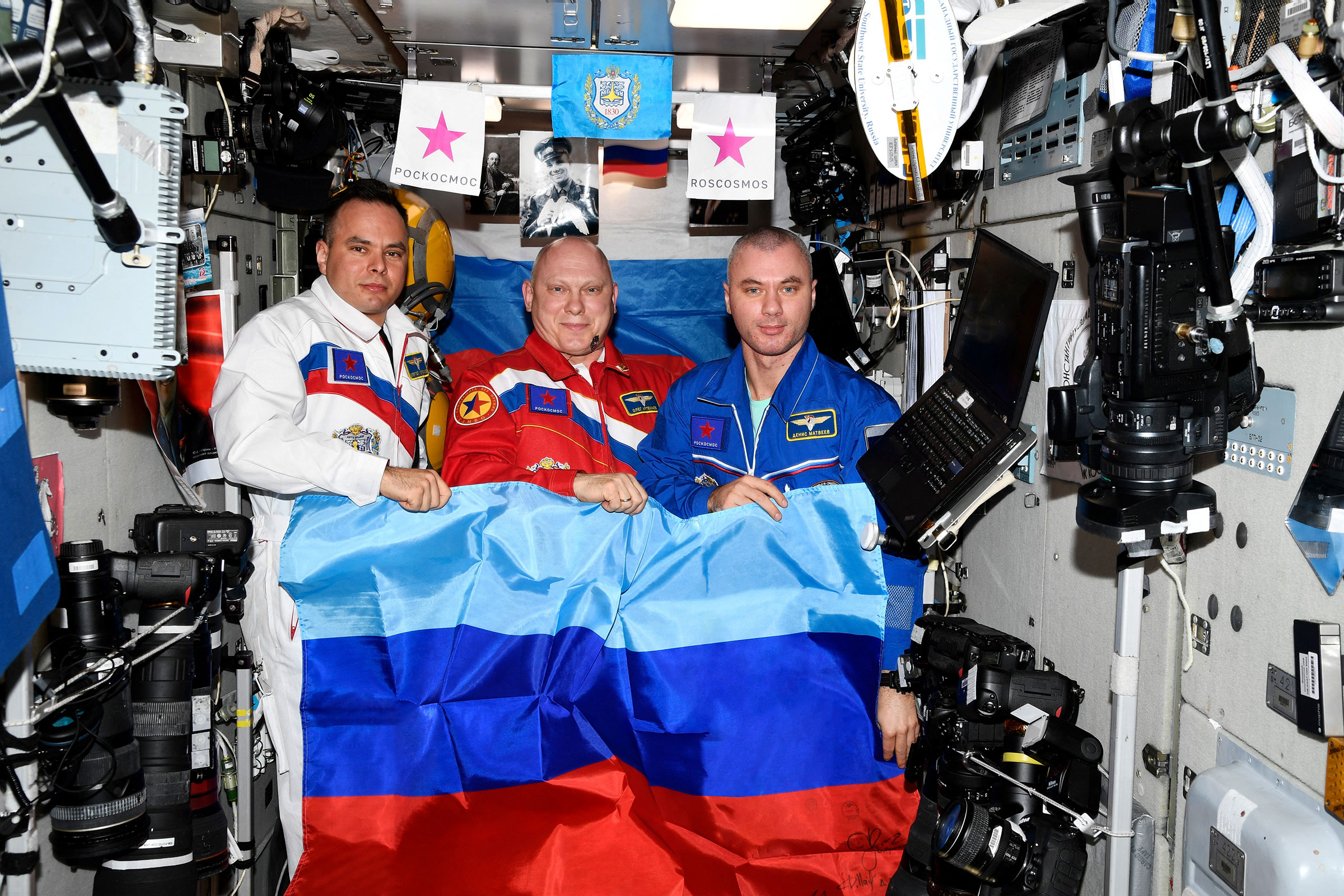 Russian cosmonauts pose with a flag of the self-proclaimed Luhansk People's Republic at the International Space Station