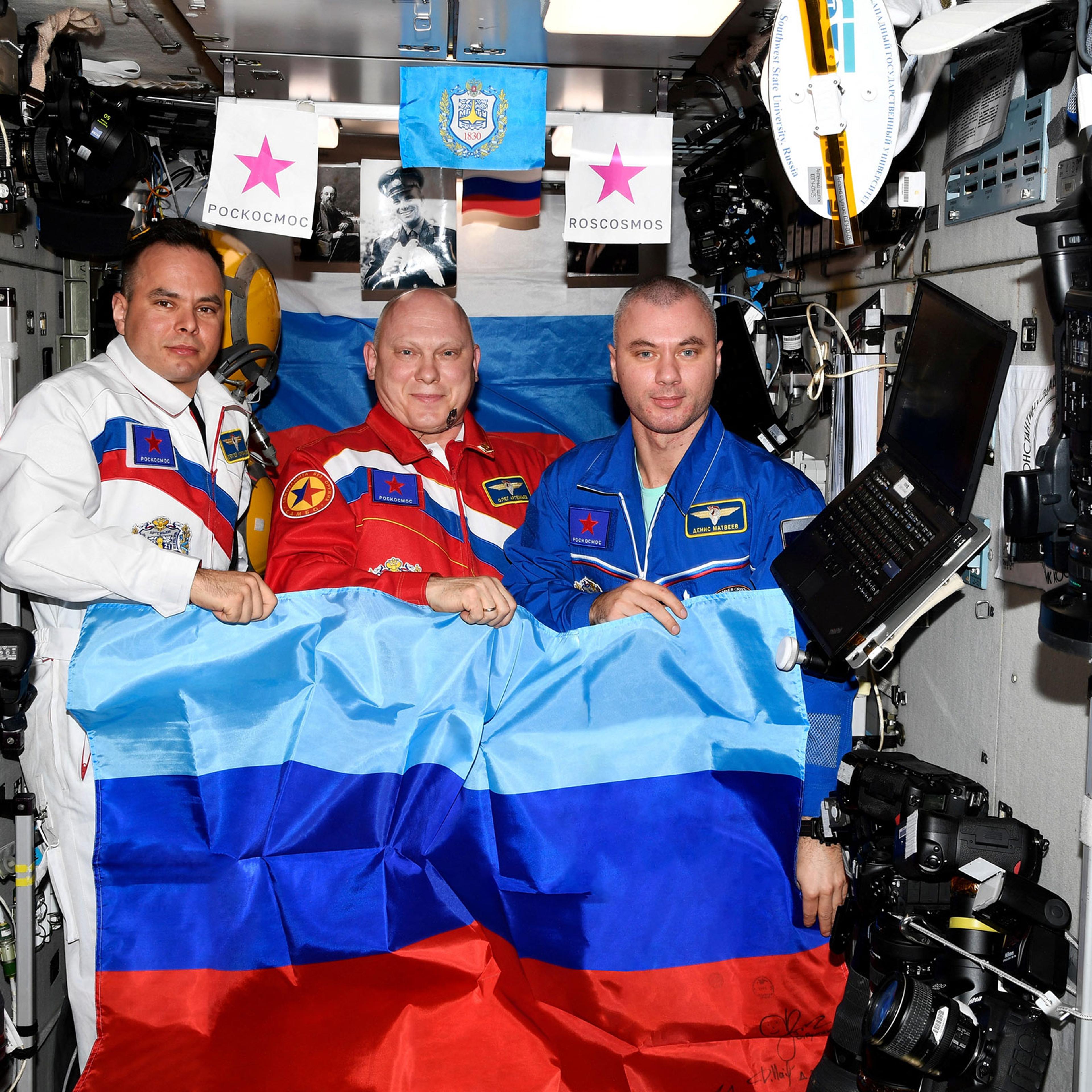 Russian cosmonauts pose with a flag of the self-proclaimed Luhansk People's Republic at the International Space Station
