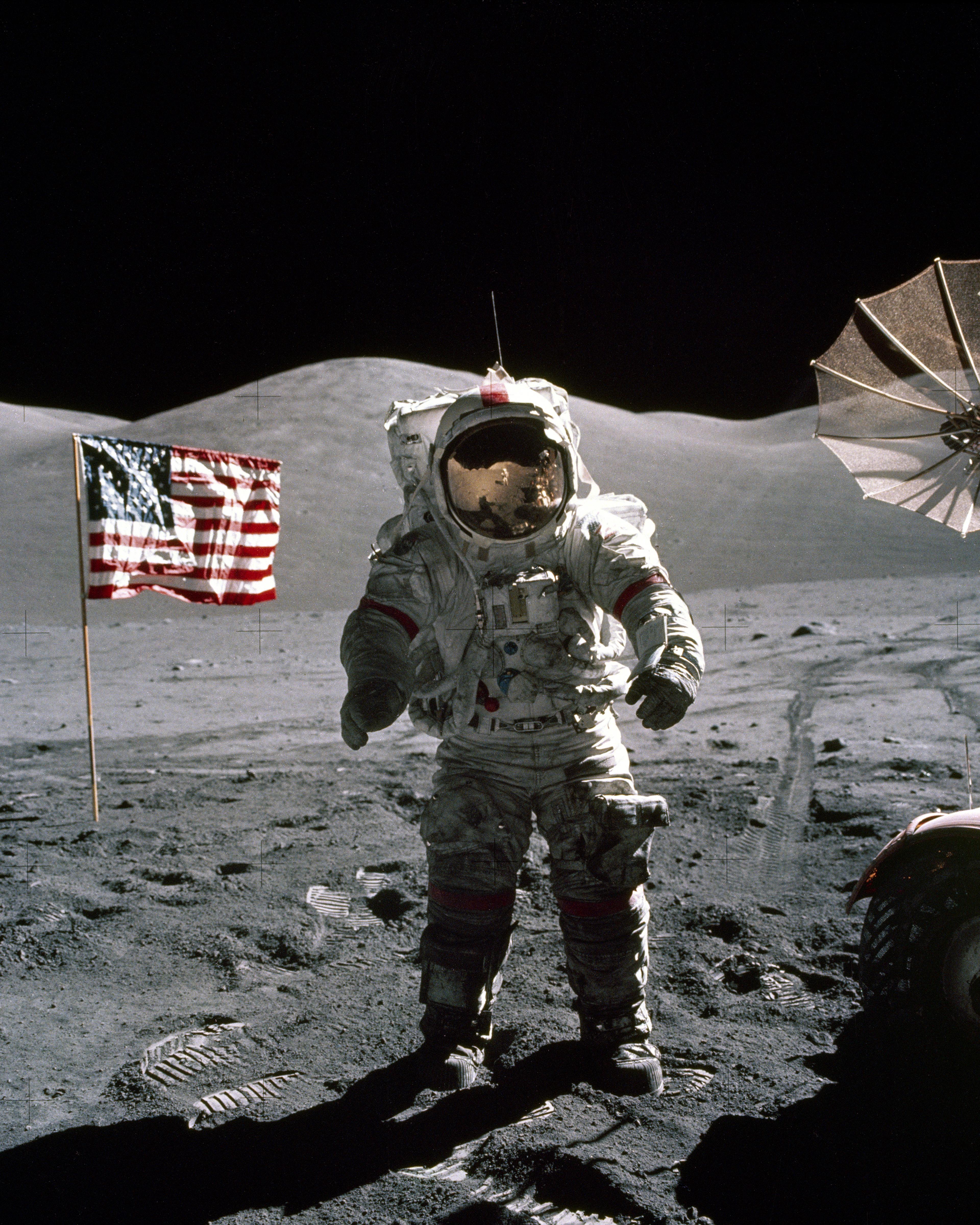 This is an Apollo 17 Astronaut standing upon the lunar surface with the United States flag in the background