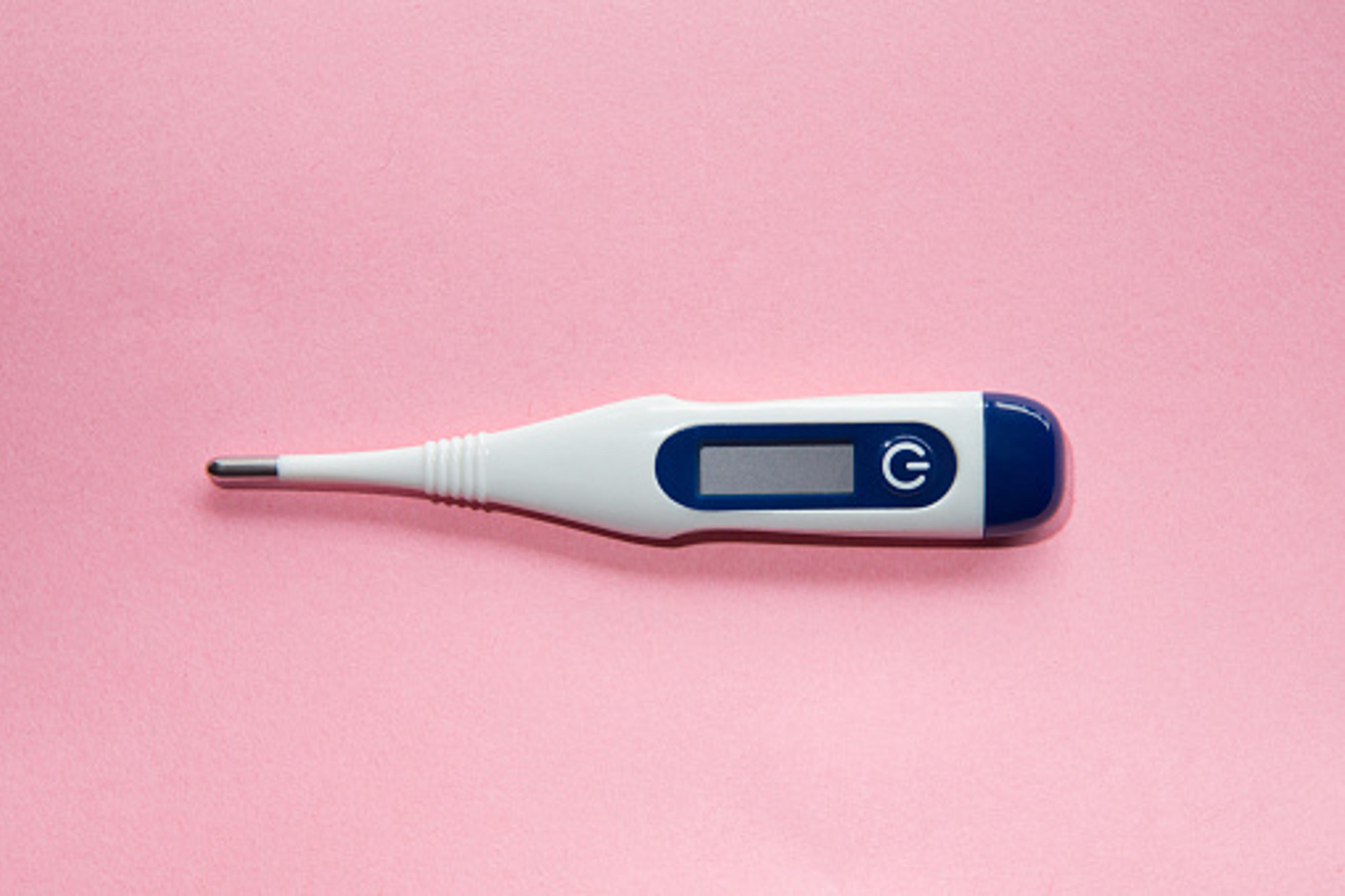 Digital thermometer on pink background