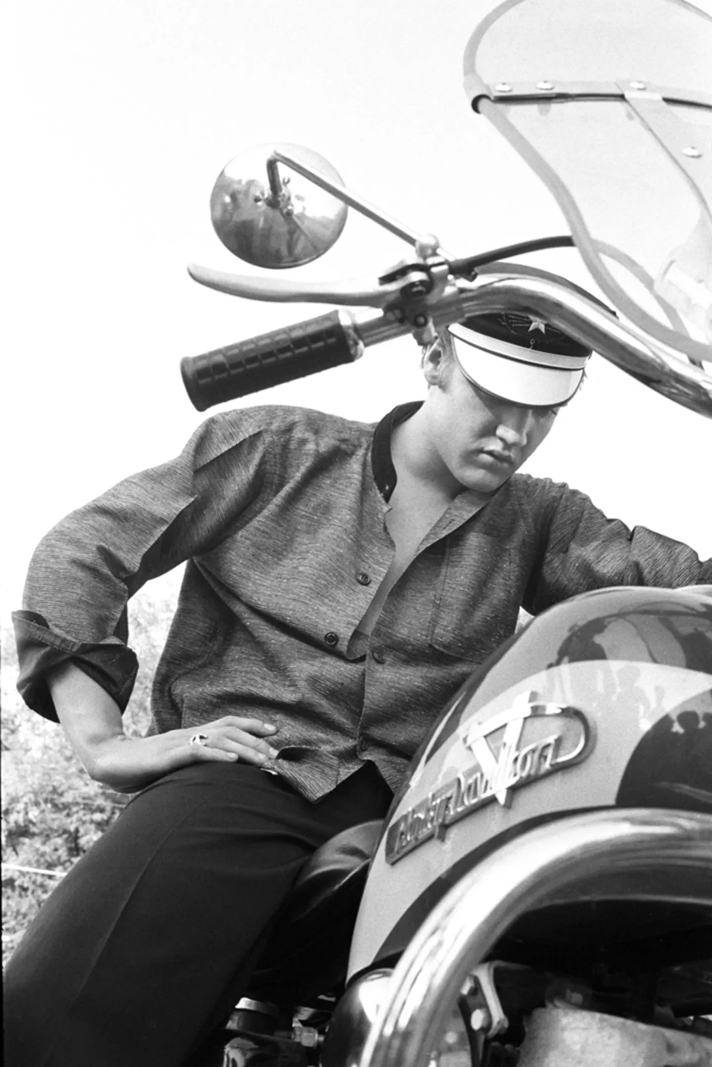 July 4, 1956. 1034 Auburn Drive, Memphis. Elvis behind his home. This is one of my iconic shots. Everyone says that I posed this, but I swear I didn’t. Why won’t the motorcycle start? No gas in the tank.