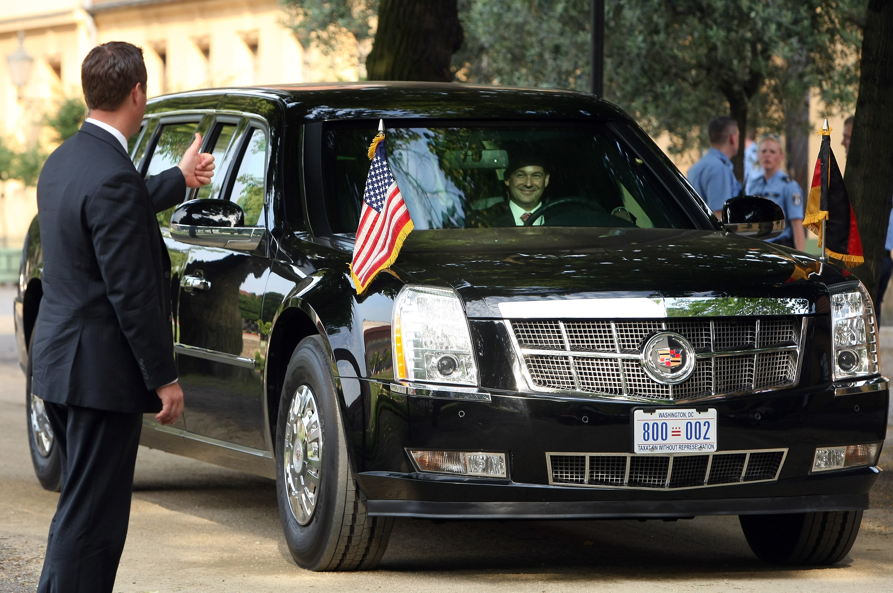 A security officer gives a thumbs-up to the driver of 'The Beast,' a modified Cadillac DTS that is the current U.S. presidential limousine, after U.S. President Barack Obama exited it for a dinner at the Orangerie at Schloss Charlottenburg palace on June
