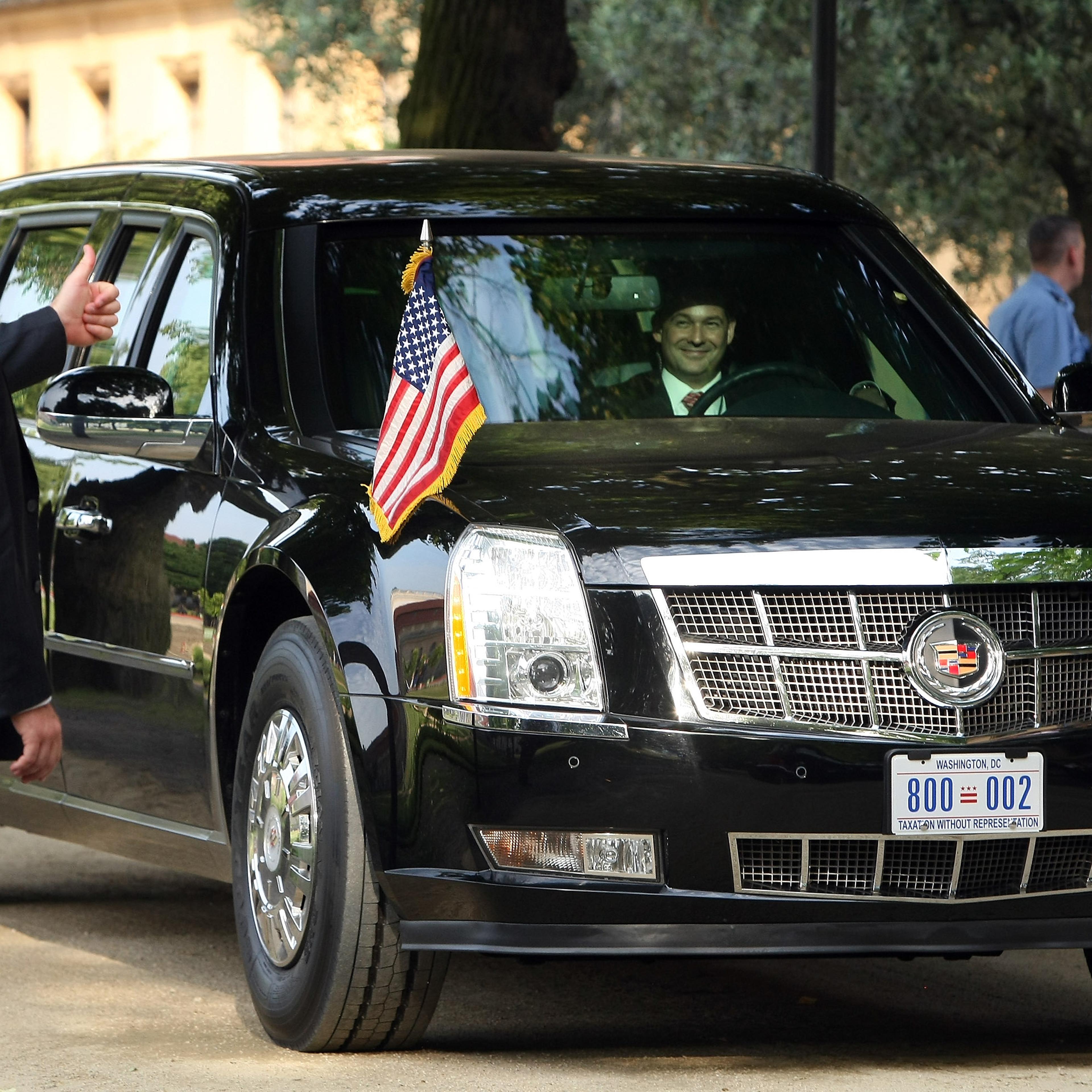 A security officer gives a thumbs-up to the driver of 'The Beast,' a modified Cadillac DTS that is the current U.S. presidential limousine, after U.S. President Barack Obama exited it for a dinner at the Orangerie at Schloss Charlottenburg palace on June