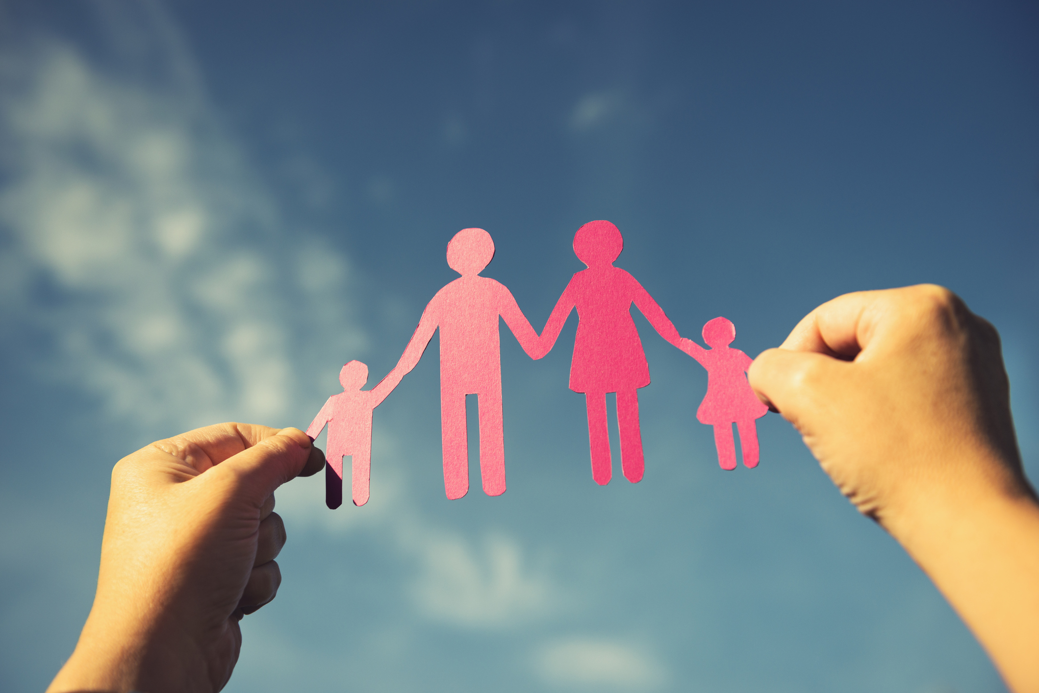 Family paper dolls against the sky