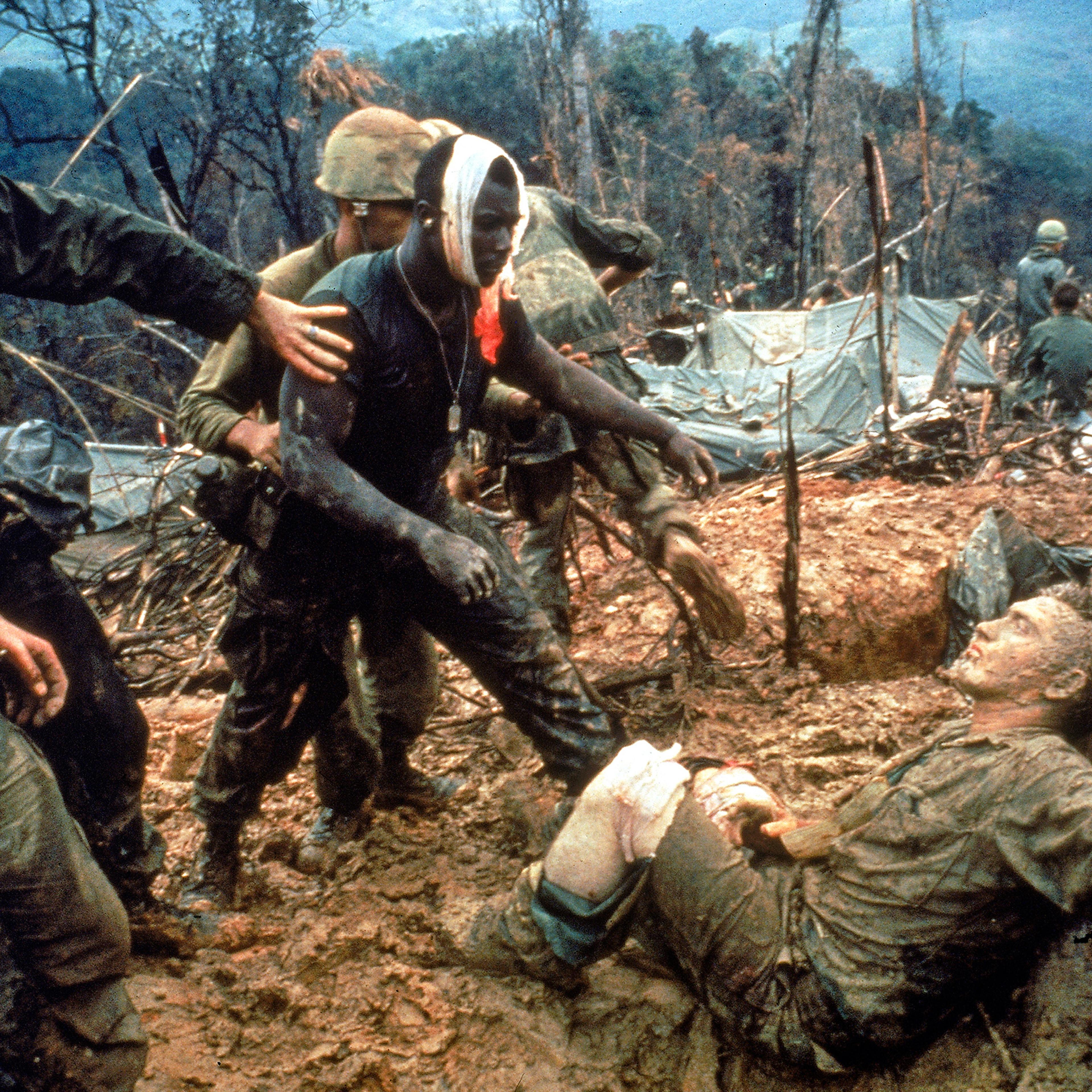 In October 1966, Marine Gunnery Sergeant Jeremiah Purdie approached a wounded comrade on Hill 484 near the DMZ, in what would become an iconic image of the war. Photographer Larry Burrows was killed in 1971