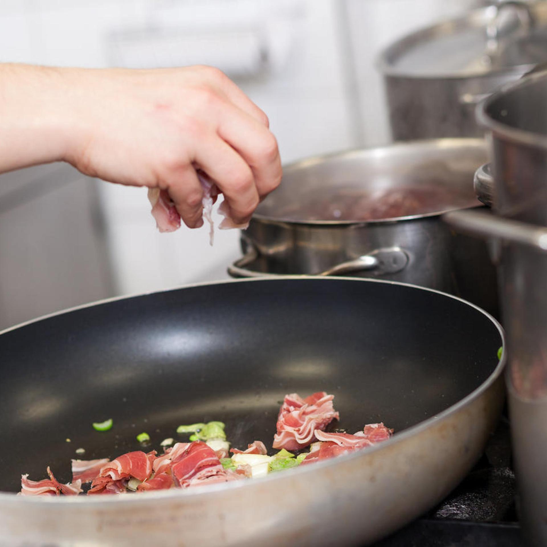 Chef or braising meat in a frying pan
