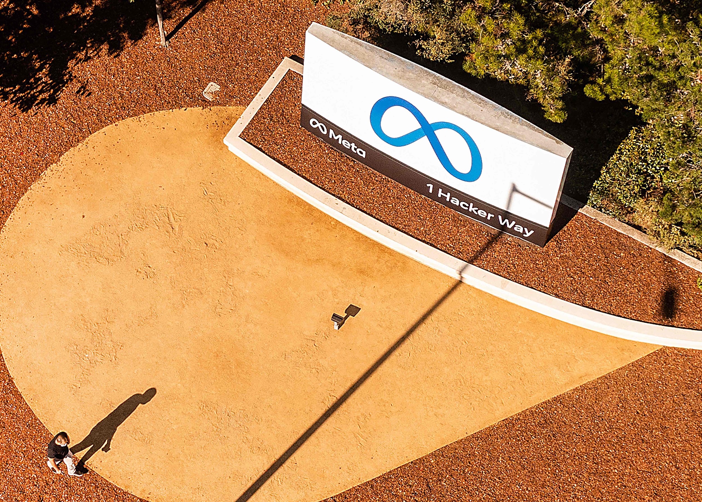 An aerial view shows a person passing a newly unveiled logo for Meta on Oct. 28, 2021 outside Meta headquarters in Menlo Park.
