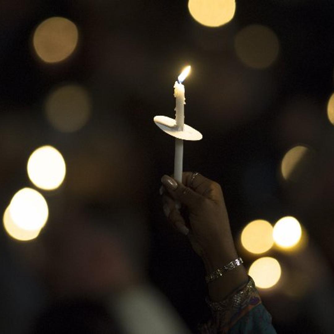 A mourner holds a candle as attending a vigil to pray for the victims of a mass shooting in San Bernardino, Calif. on Dec. 3, 2015.