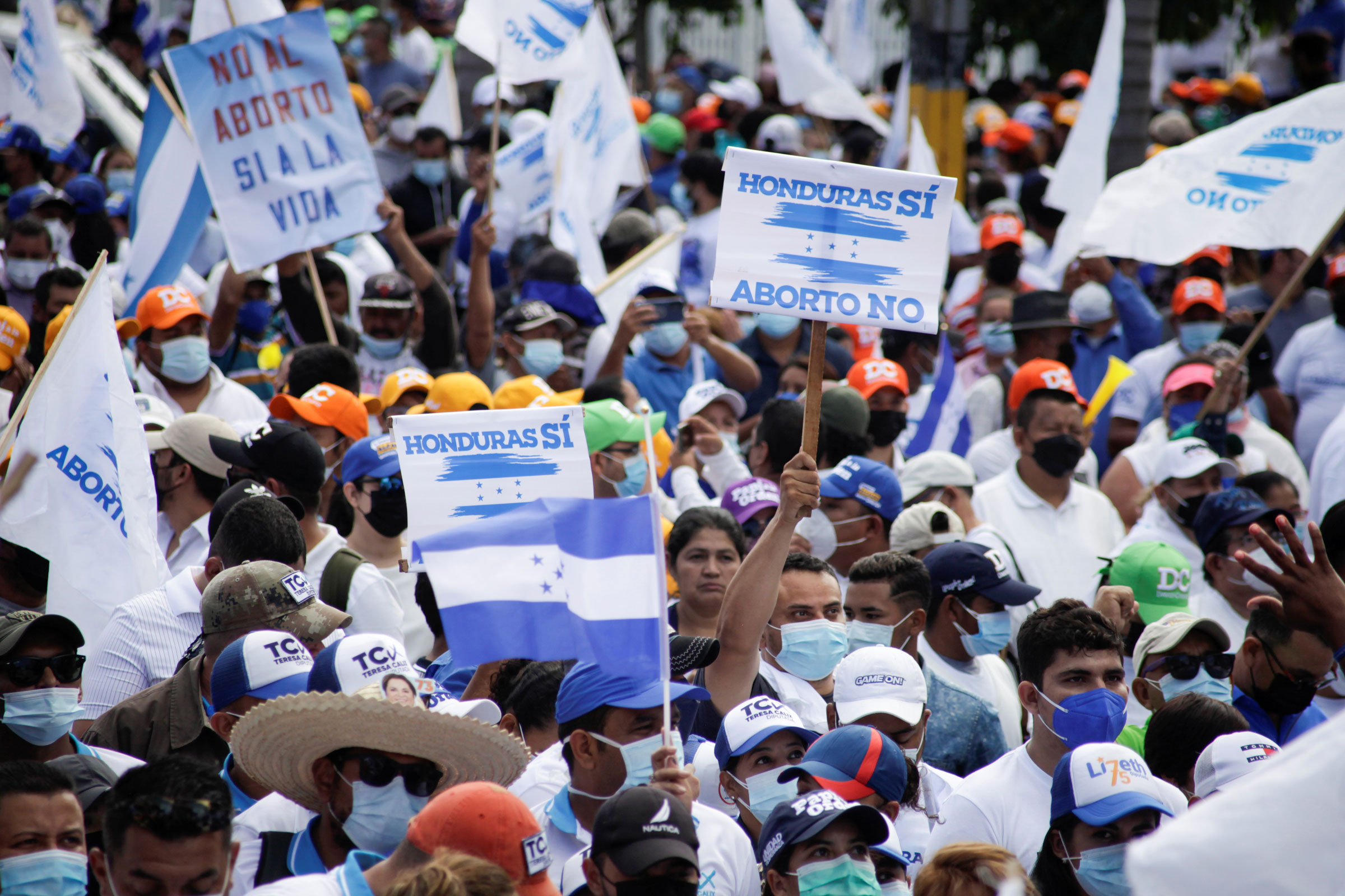 Supporters of Honduras' ruling National Party hold signs and flags reading "Honduras yes, abortion no" during a march