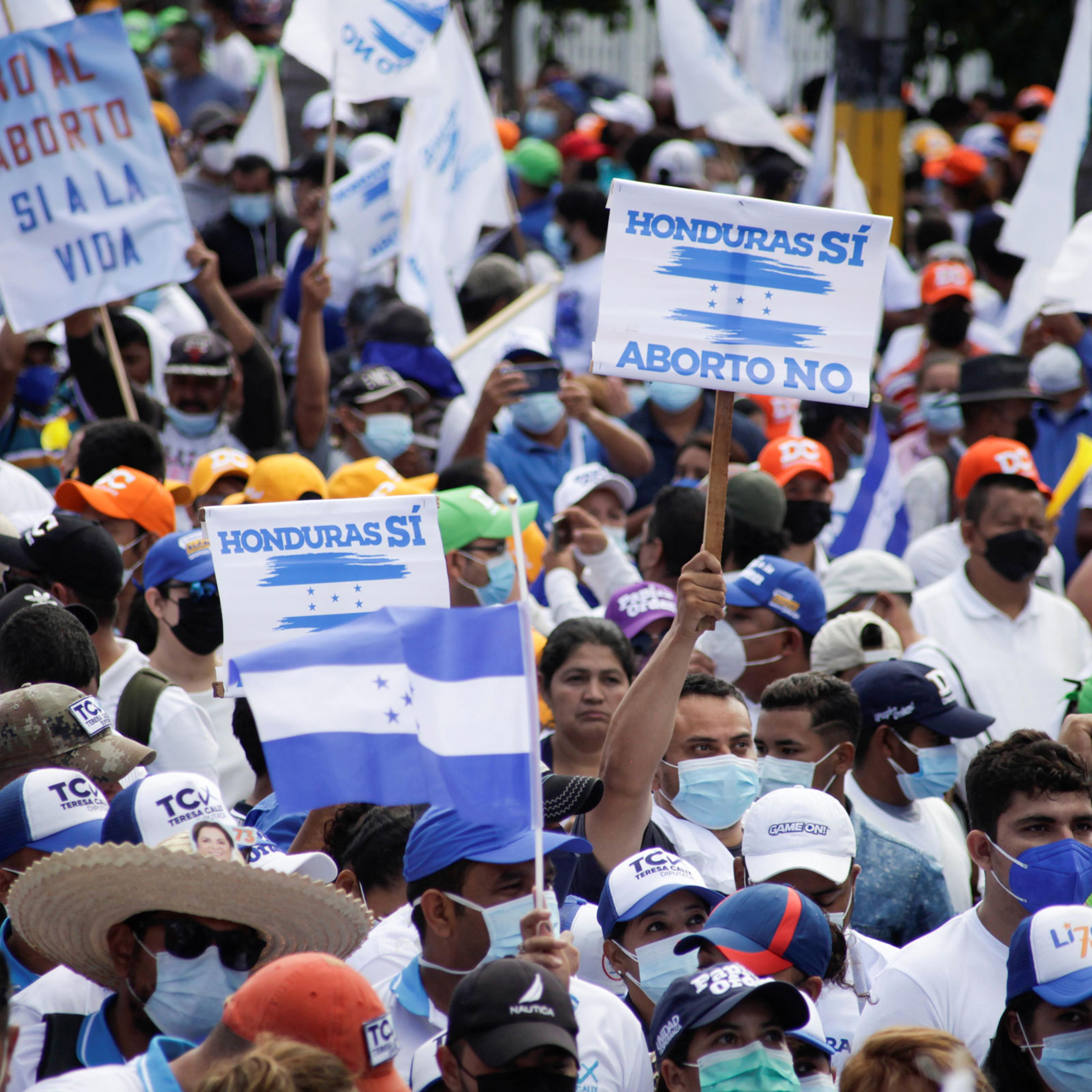 Supporters of Honduras' ruling National Party hold signs and flags reading "Honduras yes, abortion no" during a march