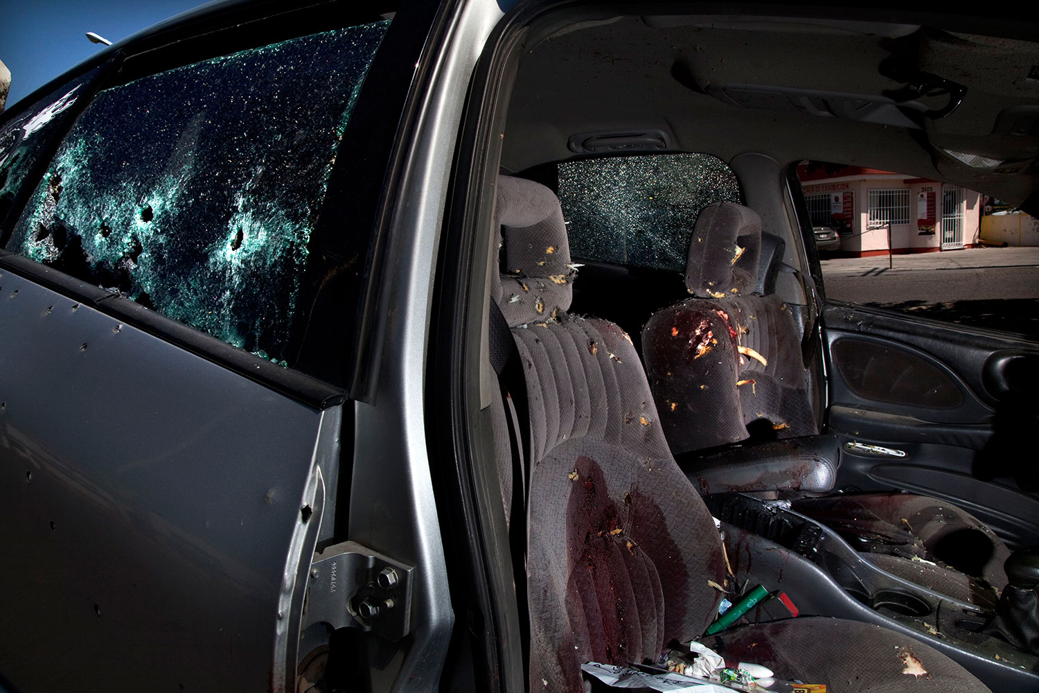 A car that took more than 54 bullets stands filled with blood in the streets of Juarez after the two bodies of the victims were taken away. June 9, 2011