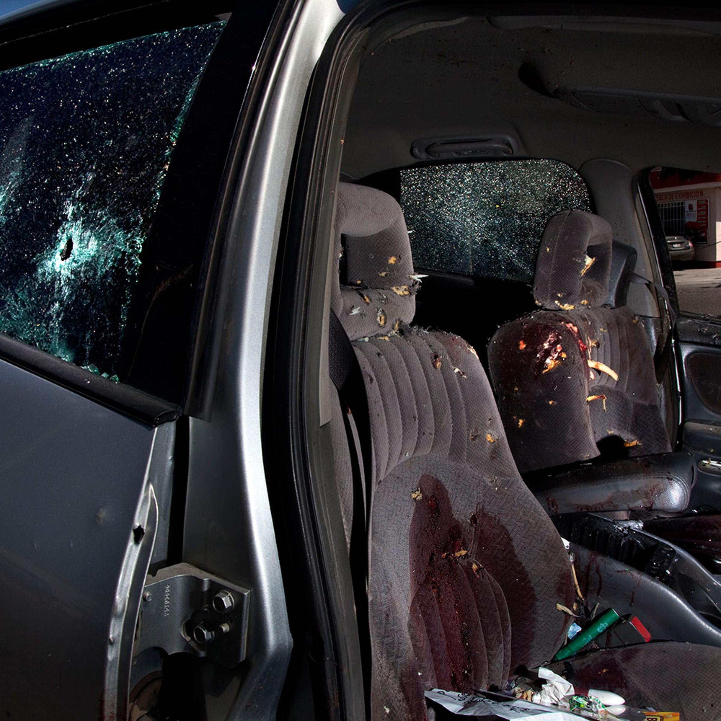 A car that took more than 54 bullets stands filled with blood in the streets of Juarez after the two bodies of the victims were taken away. June 9, 2011