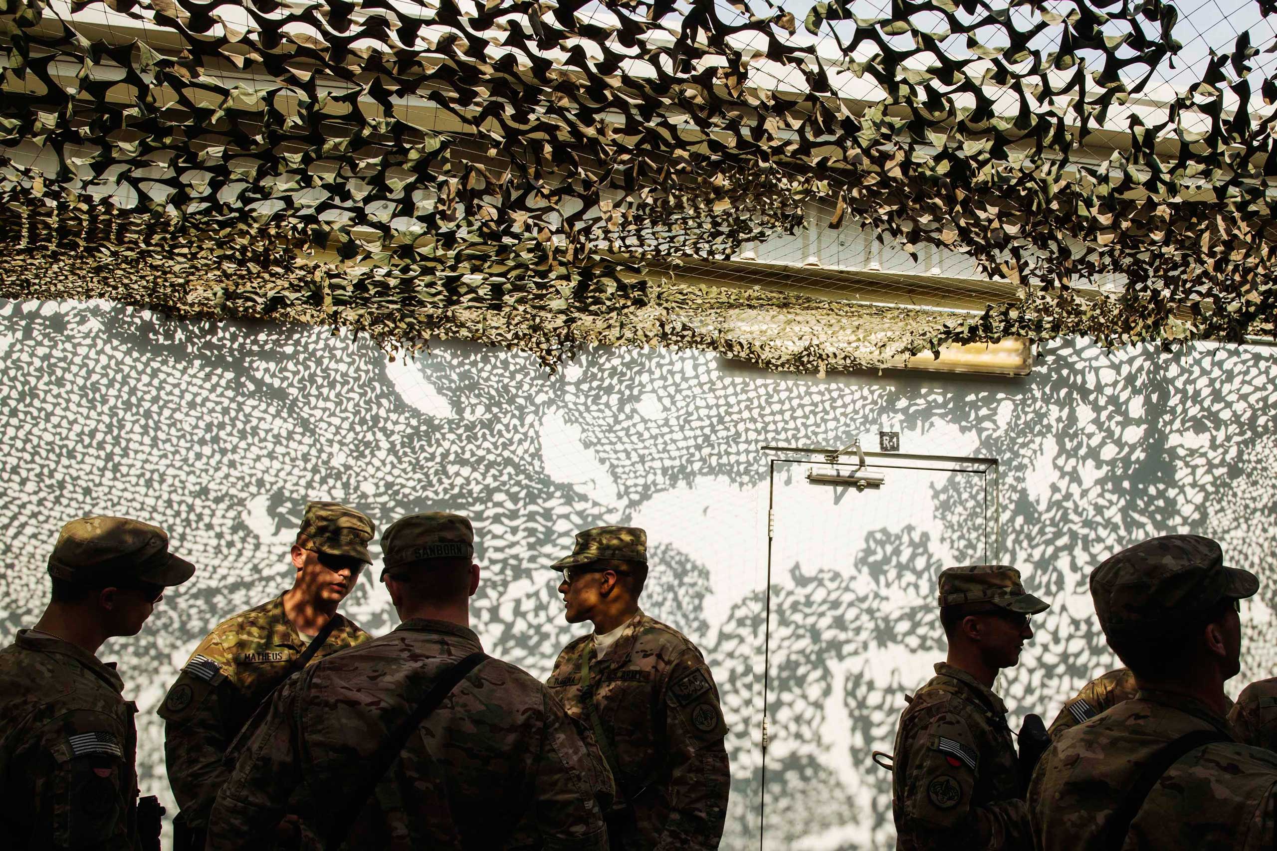 U.S. soldiers from the 3rd Cavalry Regiment wait in line to get food during a Christmas day lunch at forward operating base Gamberi in the Laghman province of Afghanistan