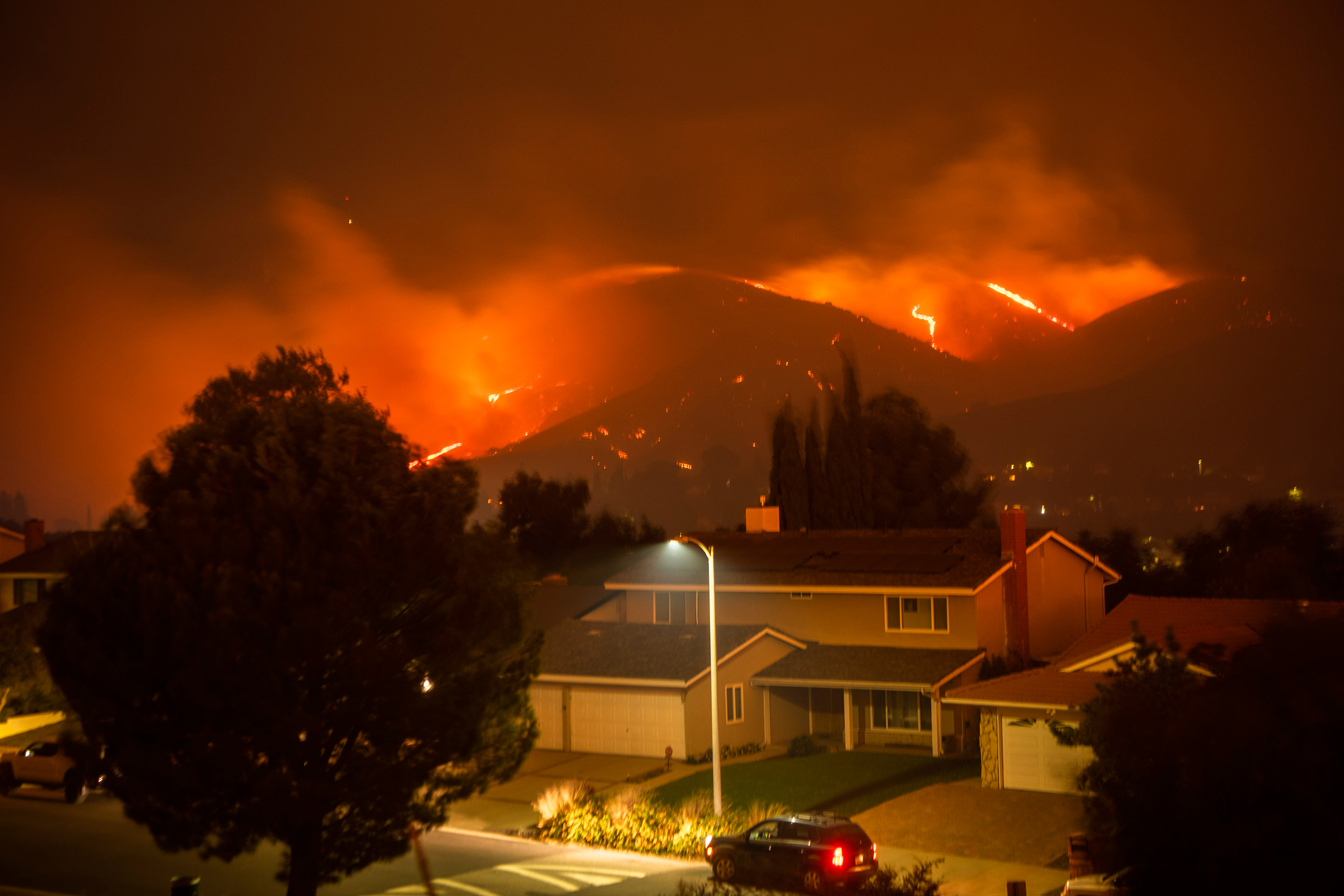 The Saddleridge Fire burns through and above Porter Ranch, Calif., early on Oct. 11, 2019.