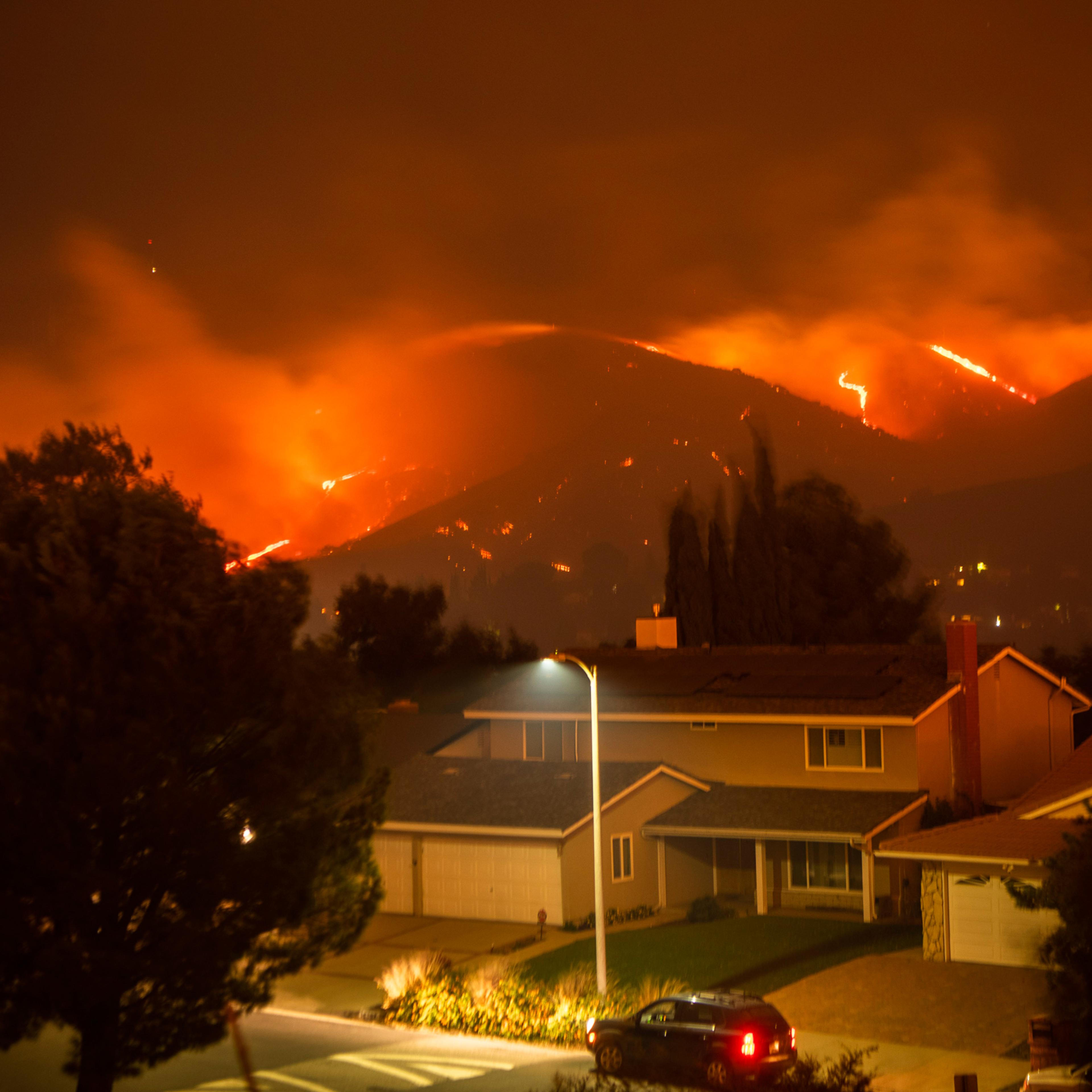 The Saddleridge Fire burns through and above Porter Ranch, Calif., early on Oct. 11, 2019.