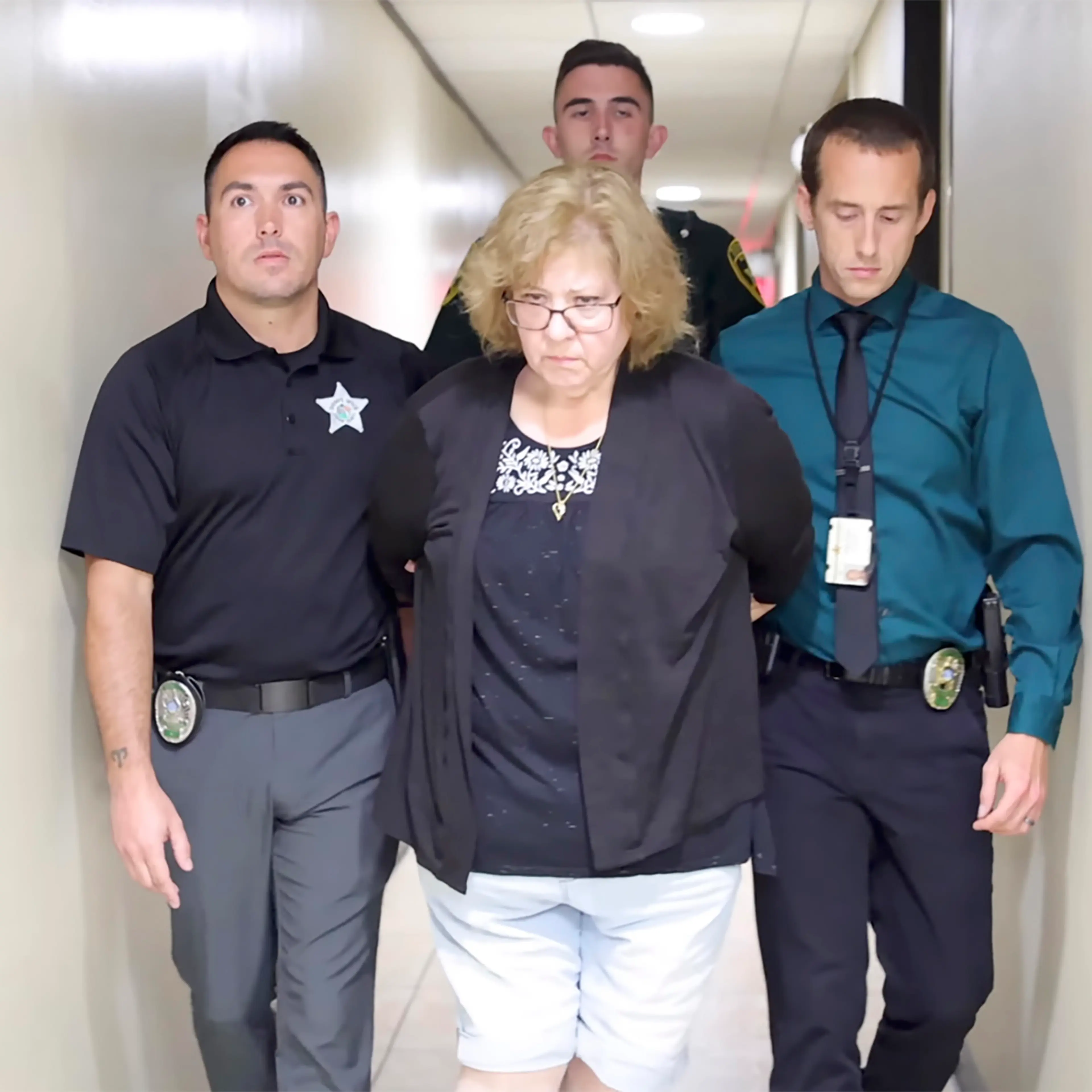 Police officers flank Susan Lorincz after her arrest.