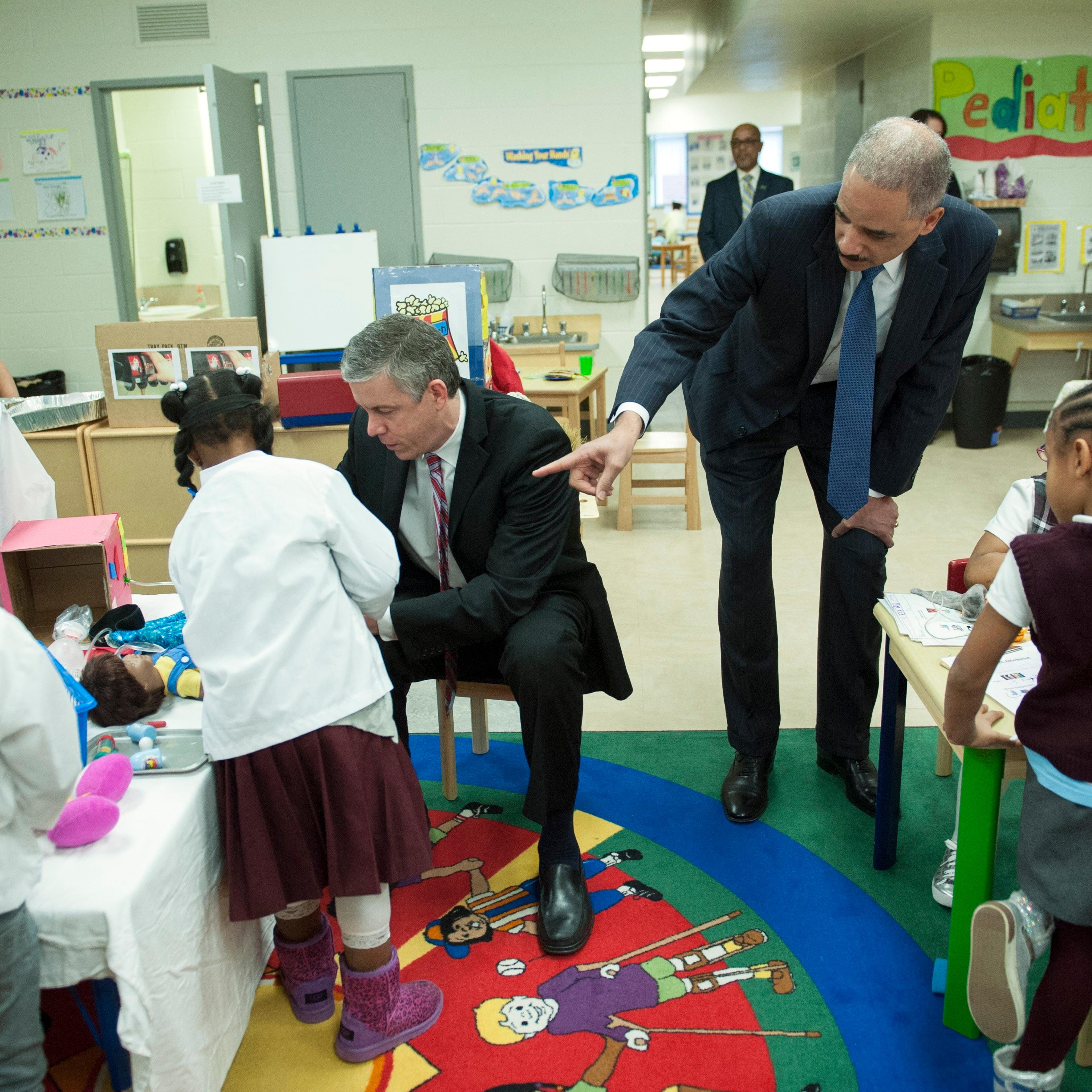 Education Secretary Arne Duncan and Attorney General Eric Holder meet with a preschool class prior to participating in a discussion on the importance of universal access to preschool at J. Ormond Wilson Elementary School in Washington.
