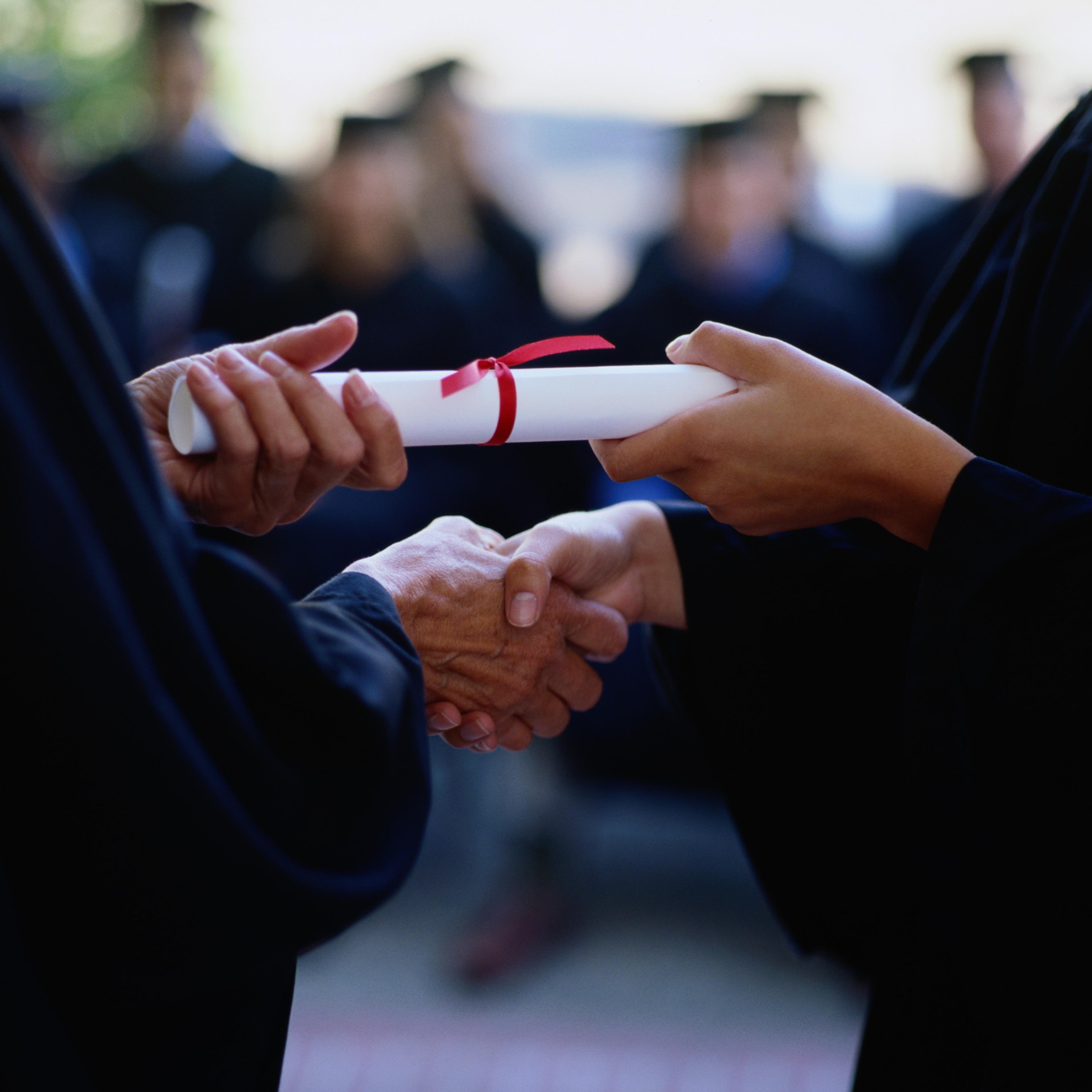 Graduate receiving a diploma, close-up of hands