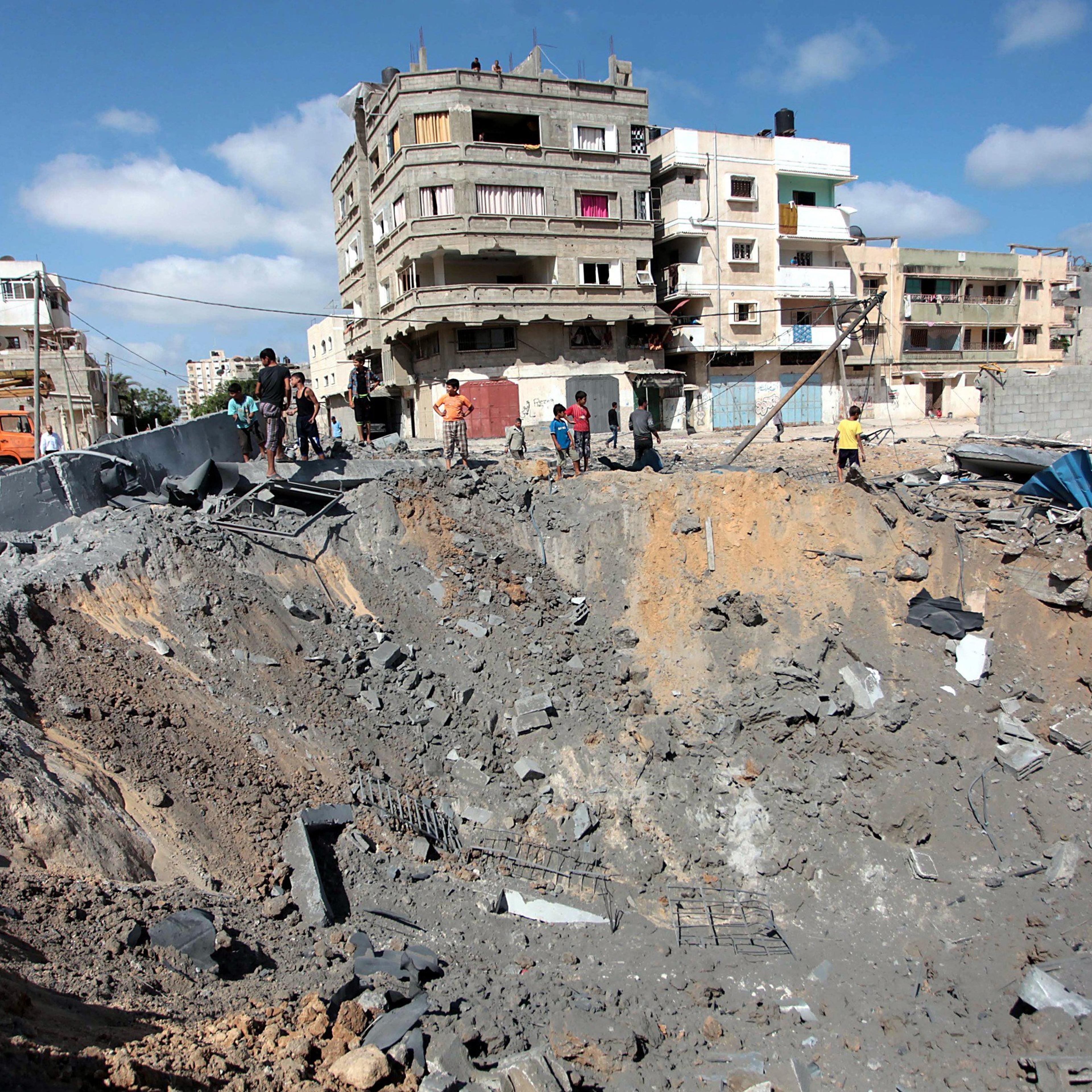 Palestinians inspect damaged areas following an overnight Israeli air strike, on July 3, 2014 in Gaza City, Gaza.