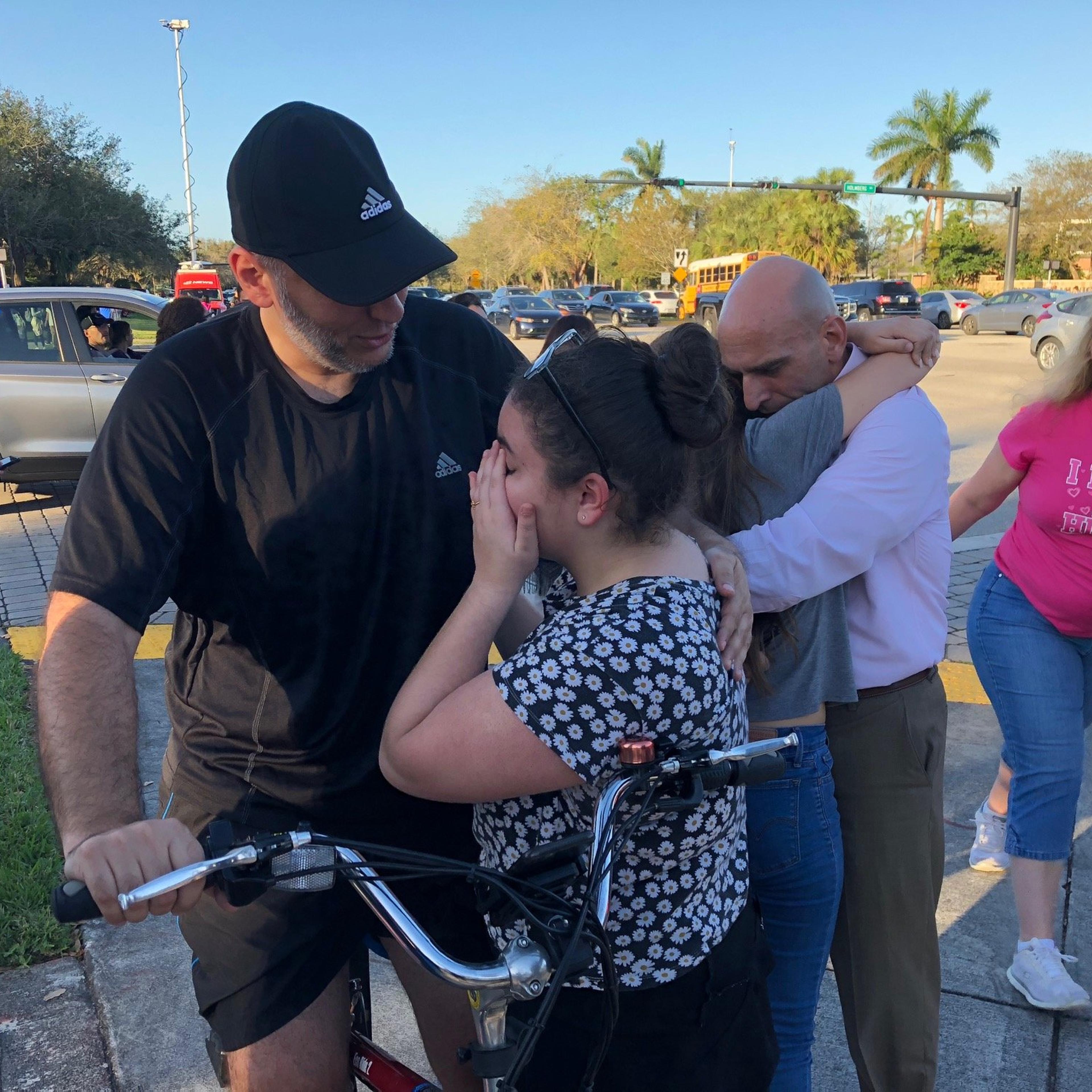 People react at Marjory Stoneman Douglas High School in Parkland, Florida, a city about 50 miles (80 kilometers) north of Miami on Feb. 14, 2018 following a school shooting.