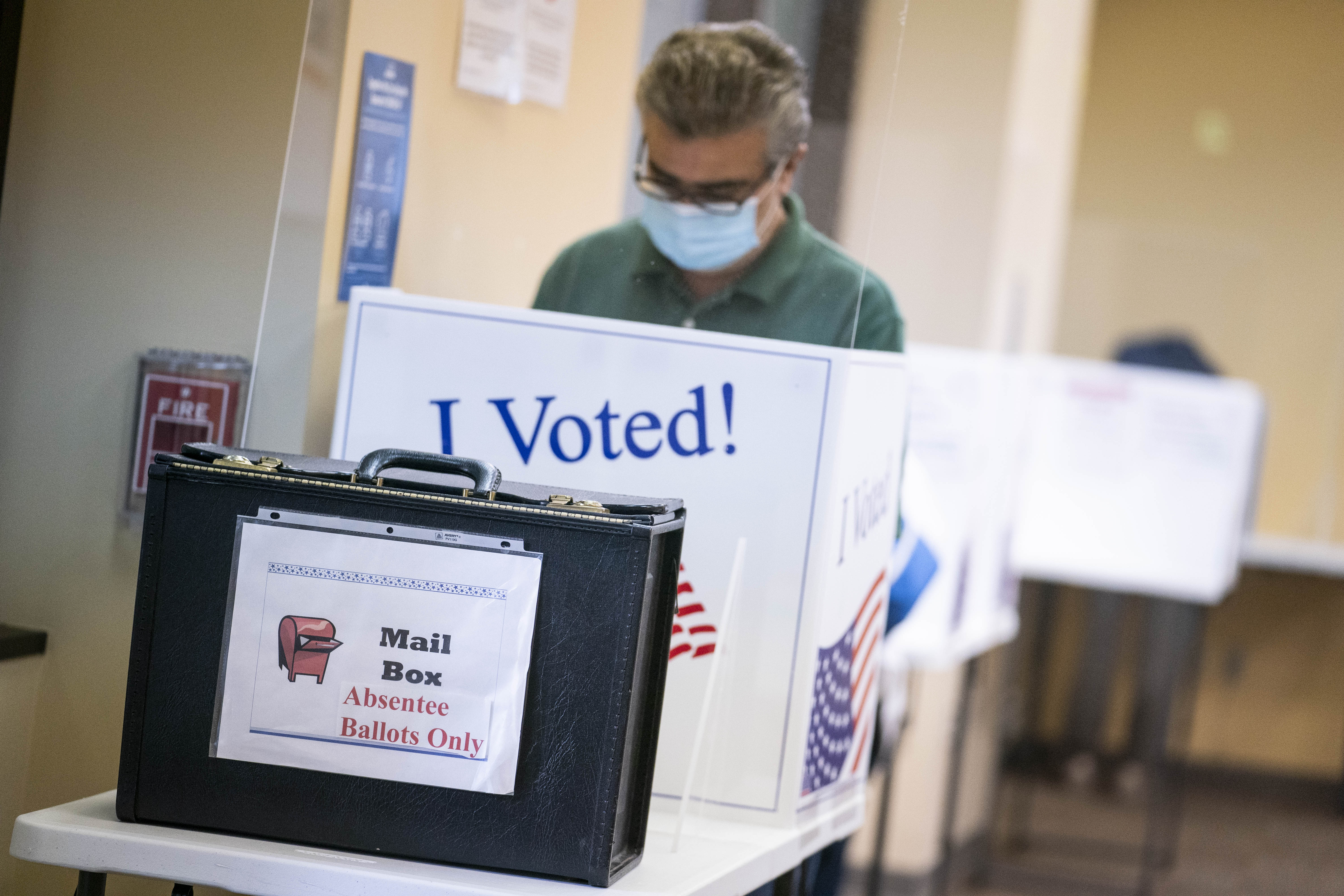 A voter wears a protective mask while casting a ballot at an early voting polling location in Arlington, Virginia, on Sept. 18, 2020.
