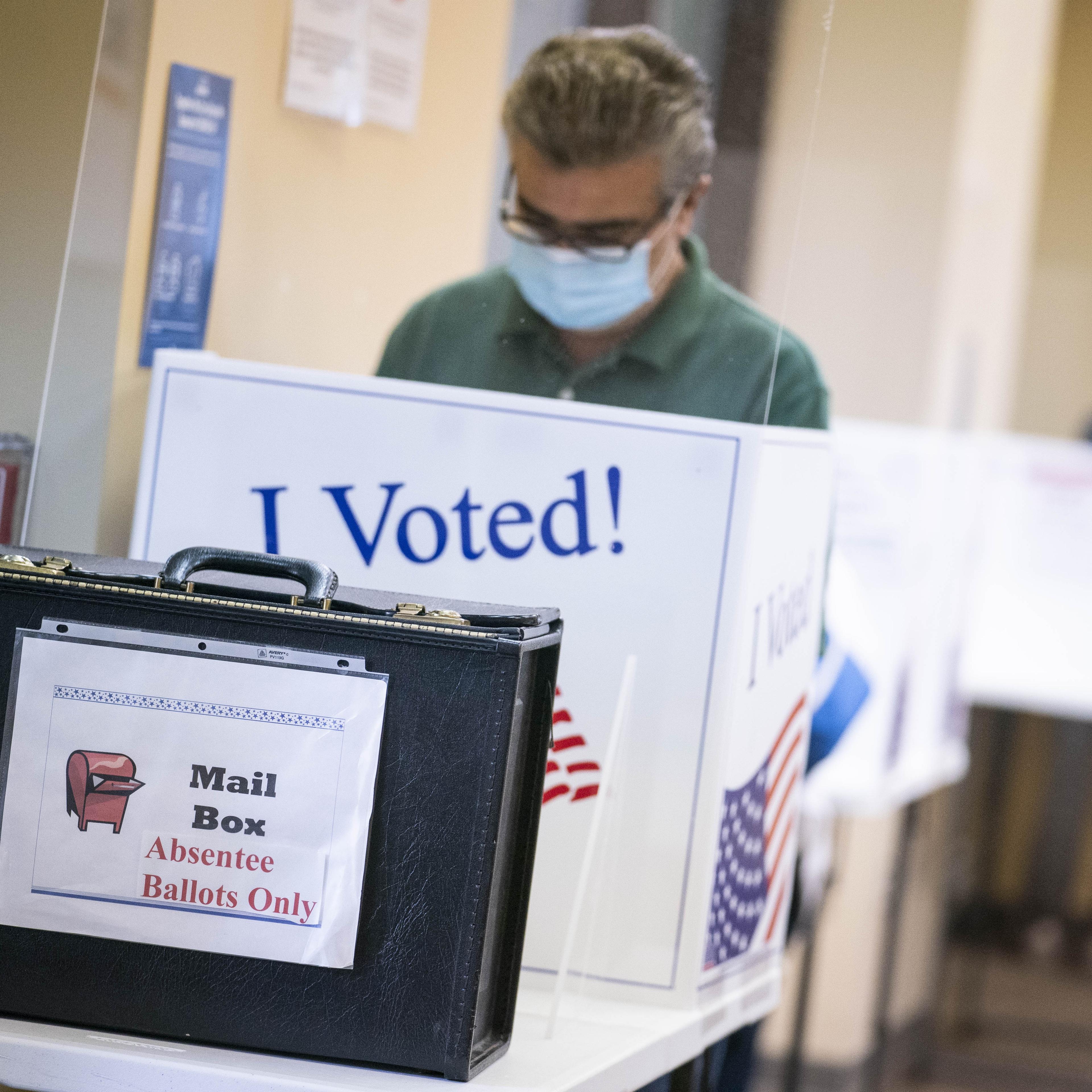 A voter wears a protective mask while casting a ballot at an early voting polling location in Arlington, Virginia, on Sept. 18, 2020.