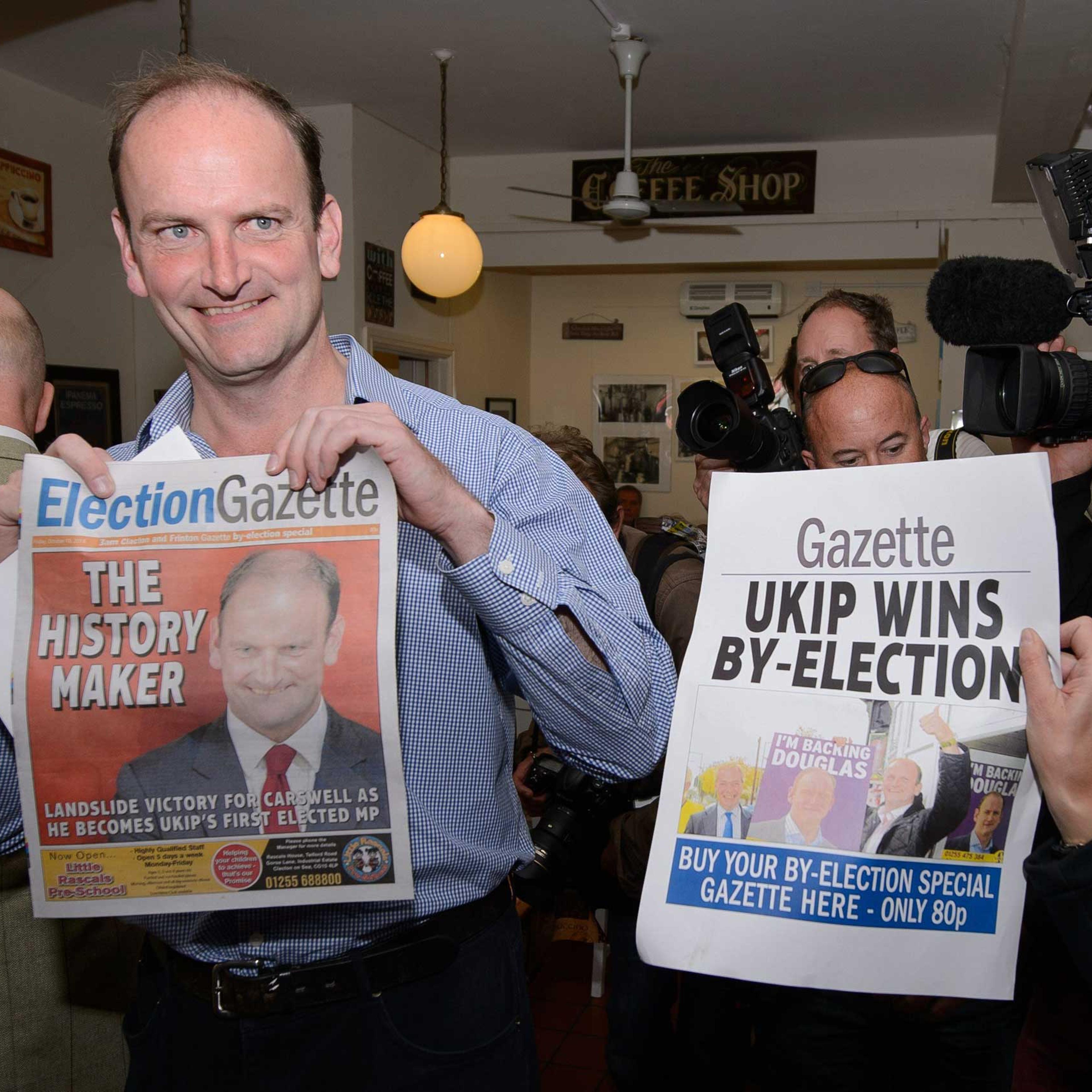 Newly-elected UK Independence Party MP Douglas Carswell poses for photographers with a copy of the local paper in Clacton-on-Sea, in eastern England, on Oct. 10, 2014.