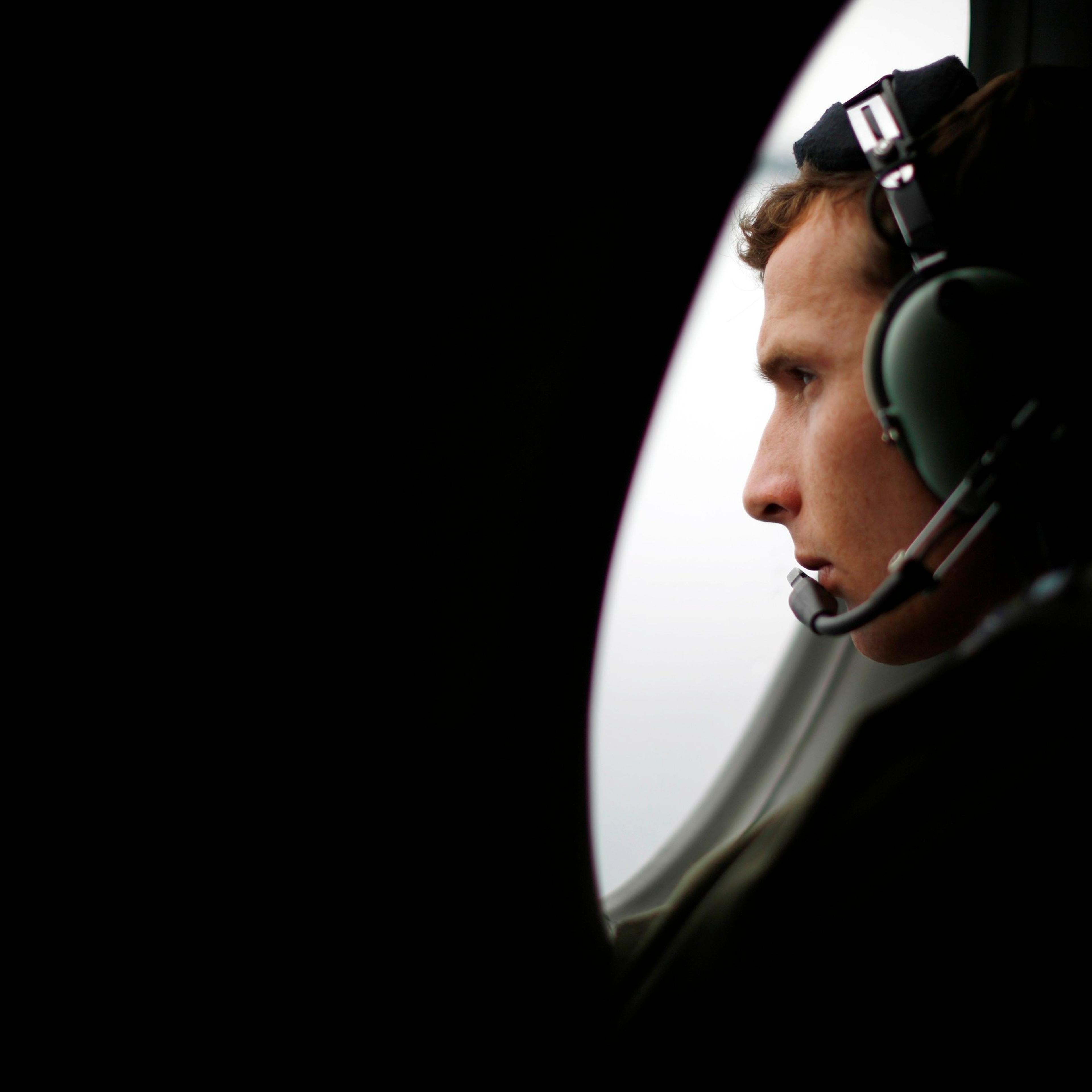 A crew member aboard a Royal New Zealand Air Force P-3K2 Orion aircraft searches for missing Malaysian Airlines flight MH370 over the southern Indian Ocean
