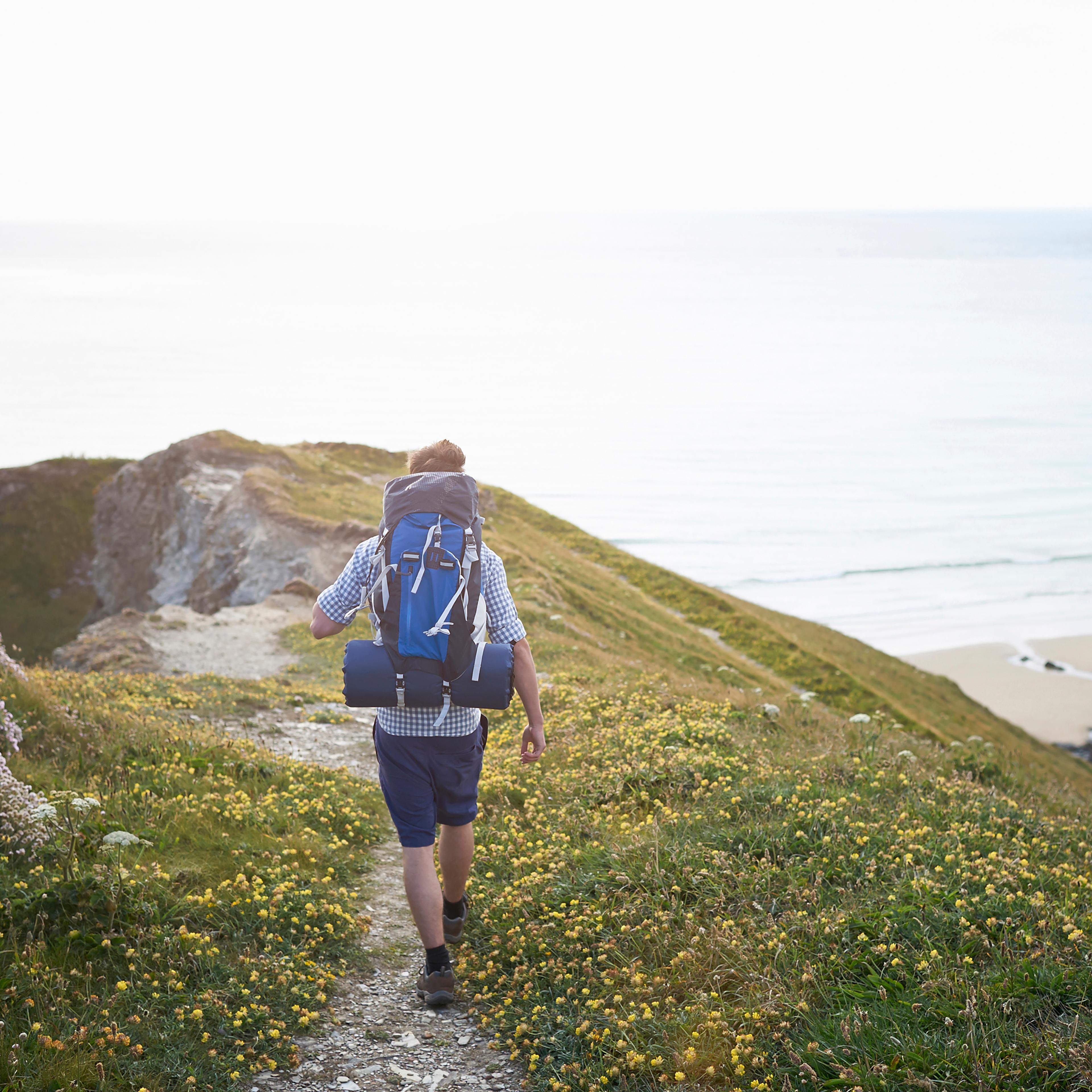 Hiker walking along coastal path