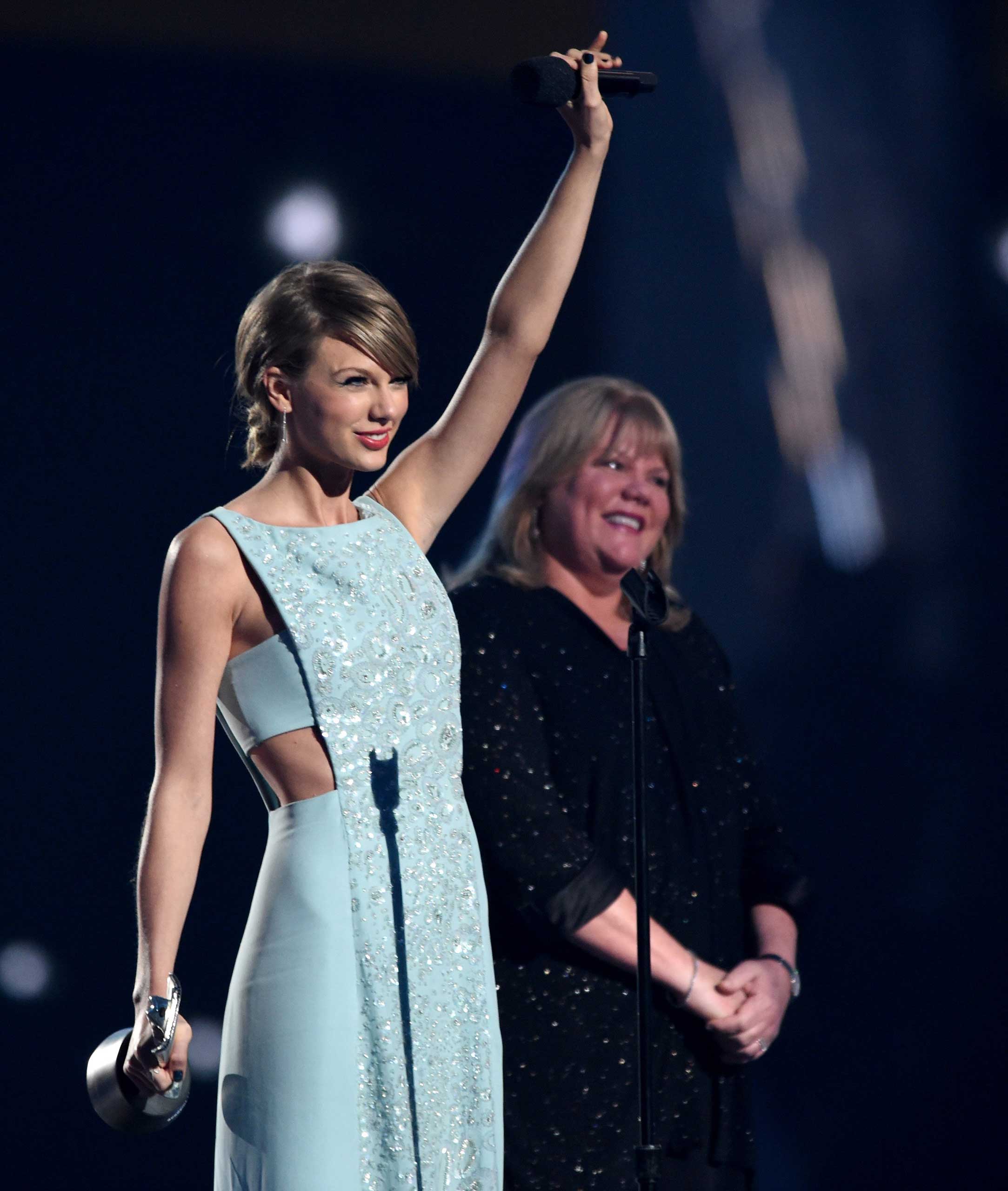 Honoree Taylor Swift accepts the Milestone Award onstage, with her mother, during the 50th Academy Of Country Music Awards at AT&T Stadium on April 19, 2015 in Arlington, Texas.