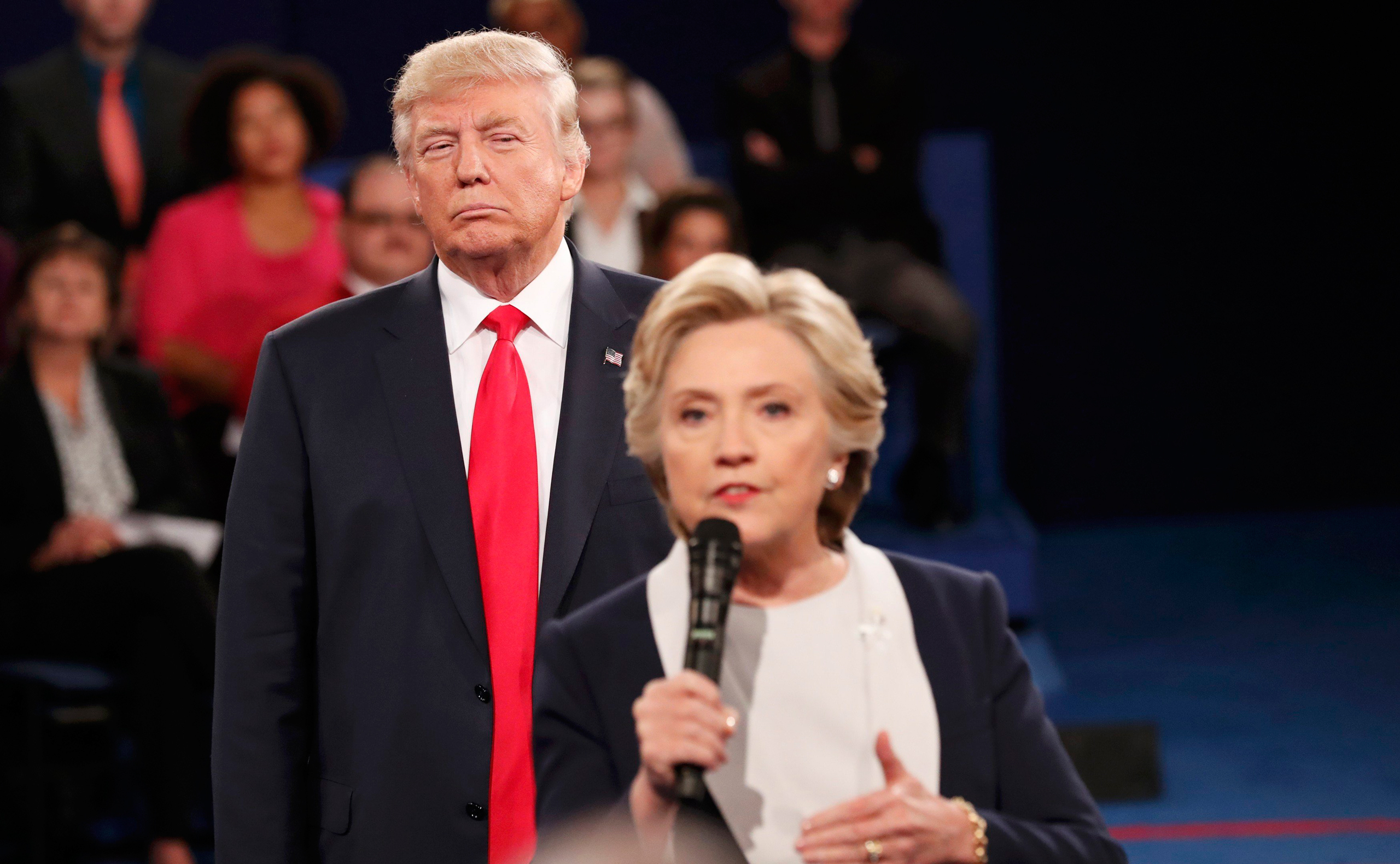 Republican U.S. presidential nominee Donald Trump listens as Democratic nominee Hillary Clinton answers a question from the audience during their presidential town hall debate at Washington University in St. Louis, Missouri, U.S., October 9, 2016. REUTER