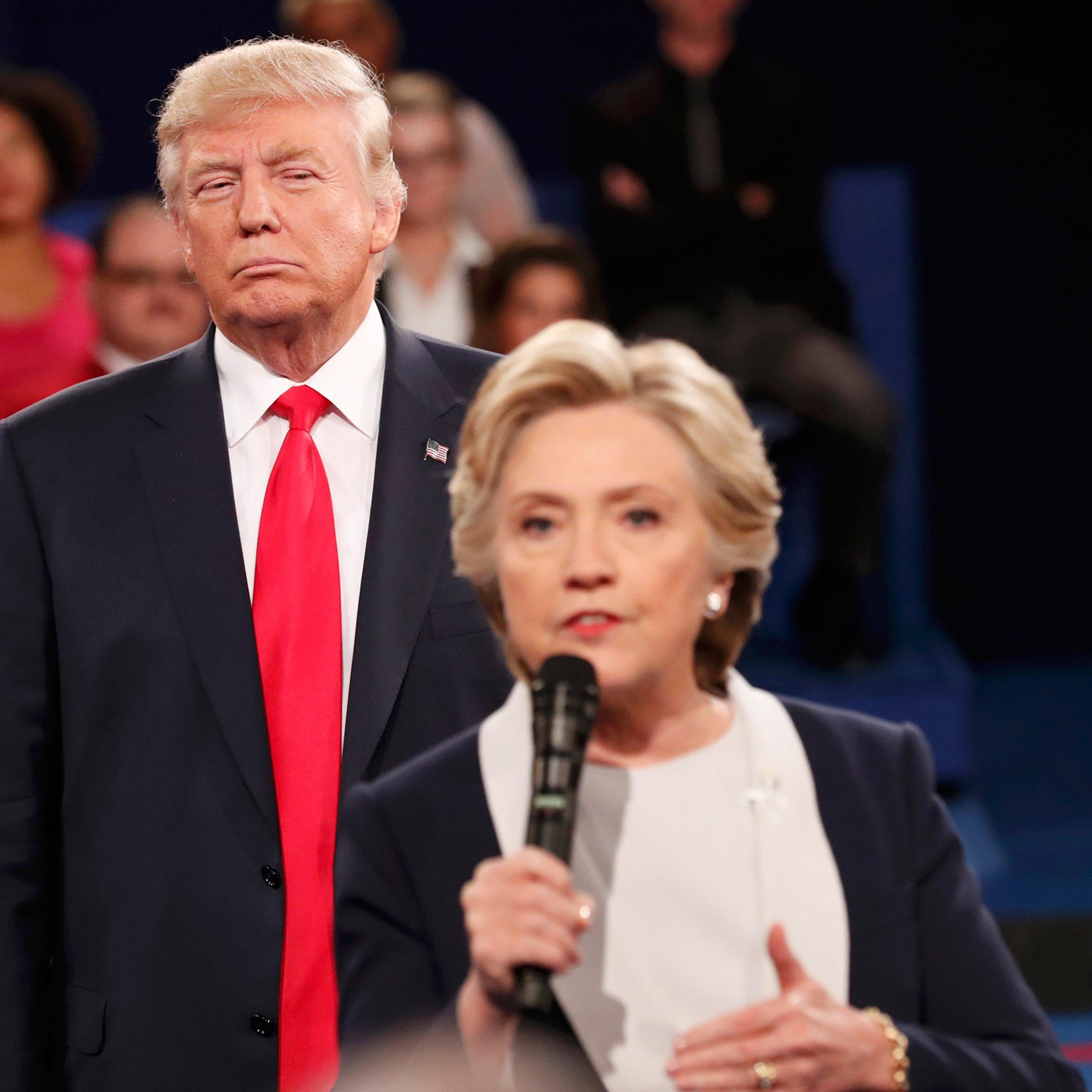 Republican U.S. presidential nominee Donald Trump listens as Democratic nominee Hillary Clinton answers a question from the audience during their presidential town hall debate at Washington University in St. Louis, Missouri, U.S., October 9, 2016. REUTER