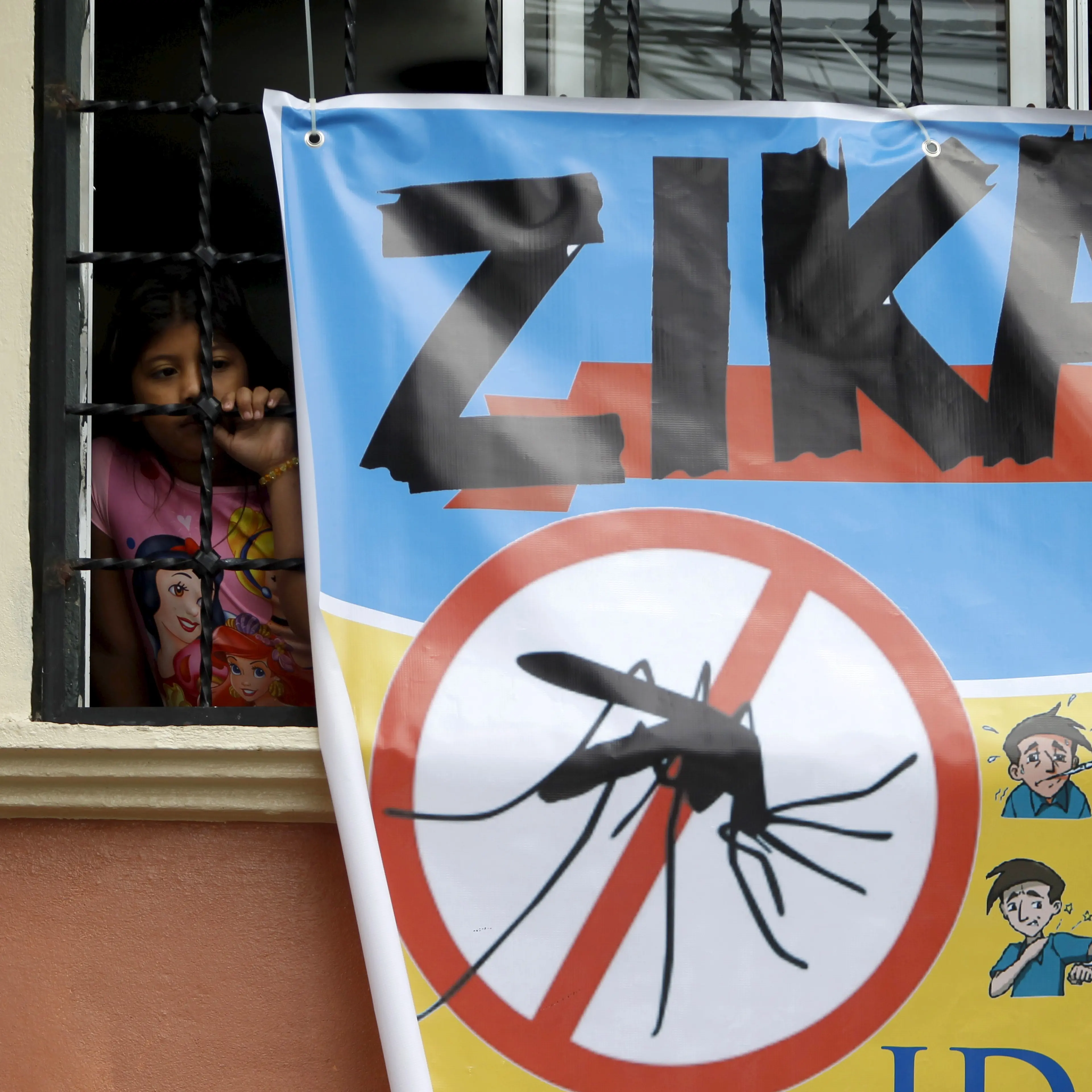 A woman looks on next to a banner as soldiers and municipal health workers take part in cleaning of the streets, gardens and homes as part of the city's efforts to prevent the spread of the Zika virus vector