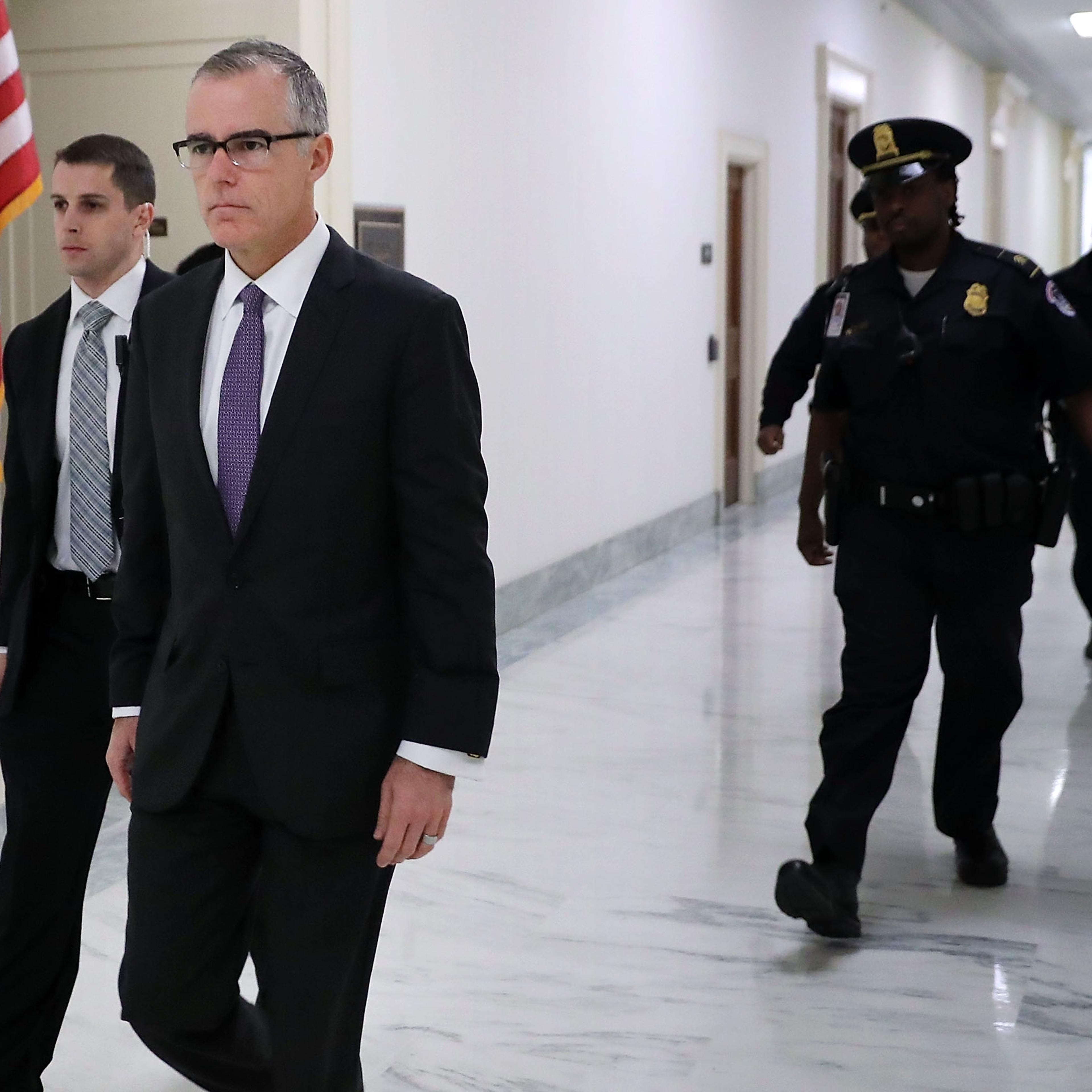 McCabe walking while being escorted by Capitol Police