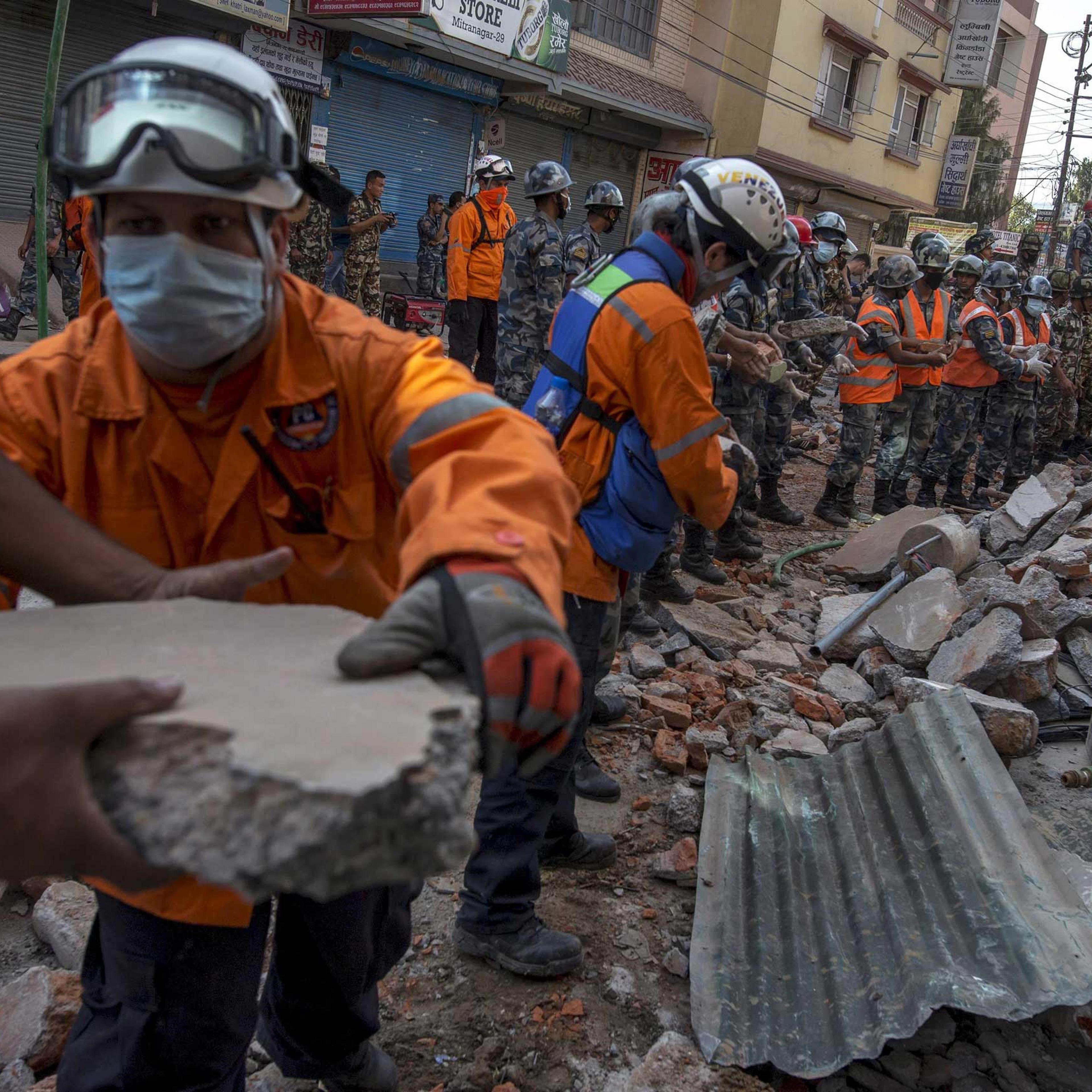 Nepalese military personnel remove debris in search of survivors after a fresh 7.3 earthquake struck, in Kathmandu on May 12, 2015.