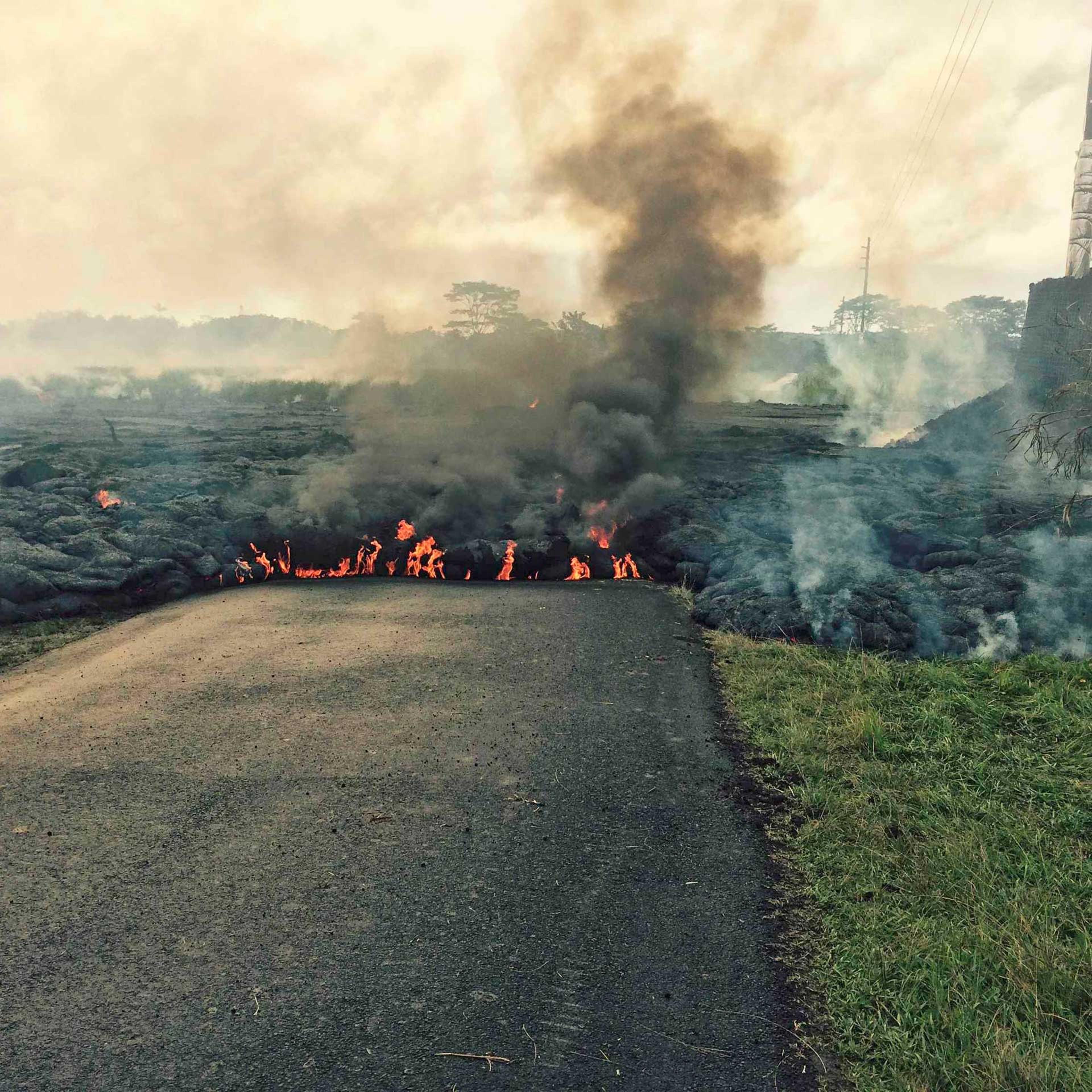 The lava flow from the Kalauea Volcano is seen crossing a road near the village of Pahoa, Hawaii