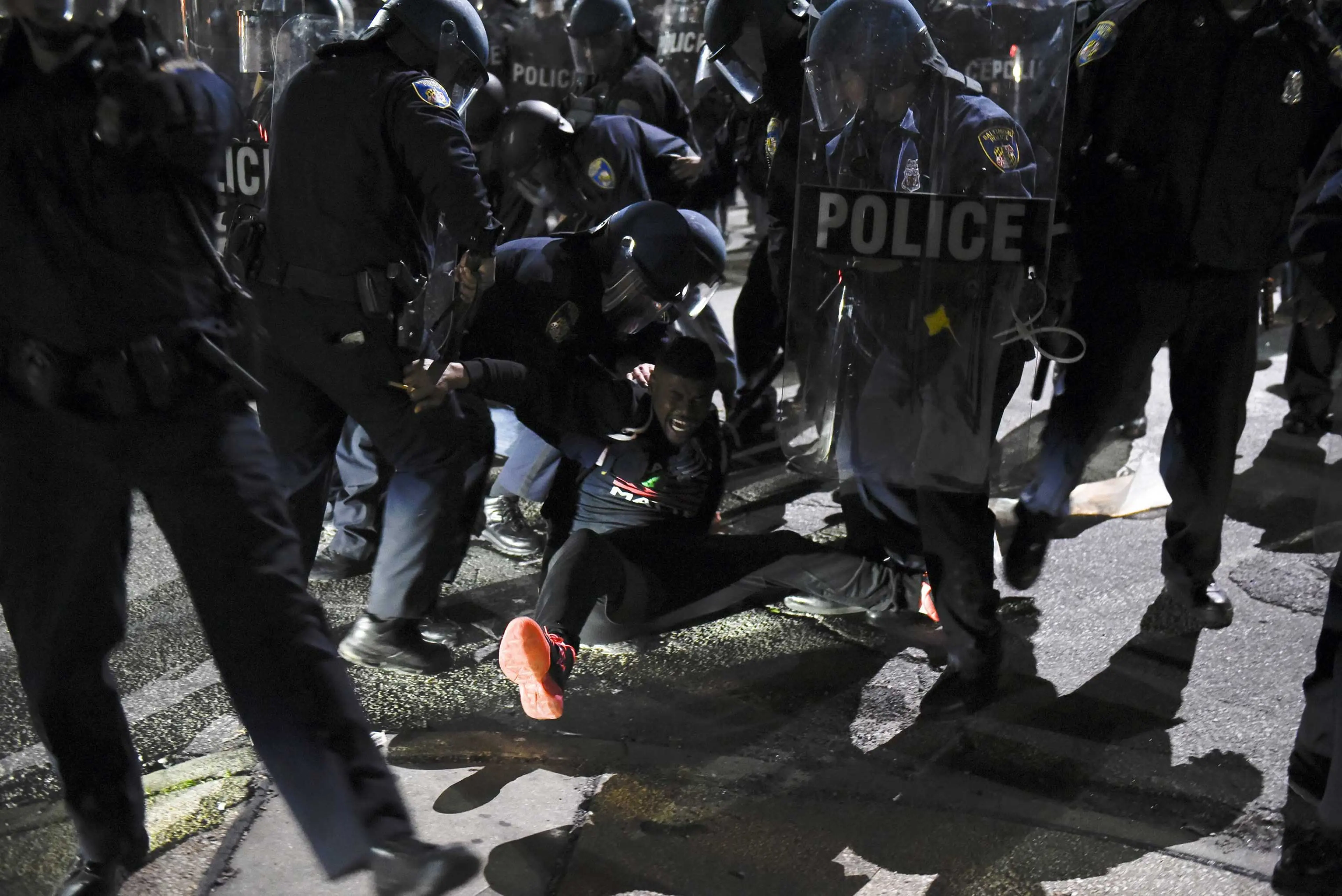 Law enforcement officers detain a demonstrator on Gilmore Avenue near Baltimore Police Department Western District during a protest against the death of Gray in police custody, in Baltimore