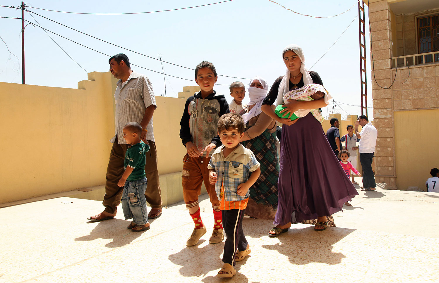 Displaced families from the minority Yazidi sect, fleeing the violence in the Iraqi town of Sinjar west of Mosul, arrive at Dohuk province