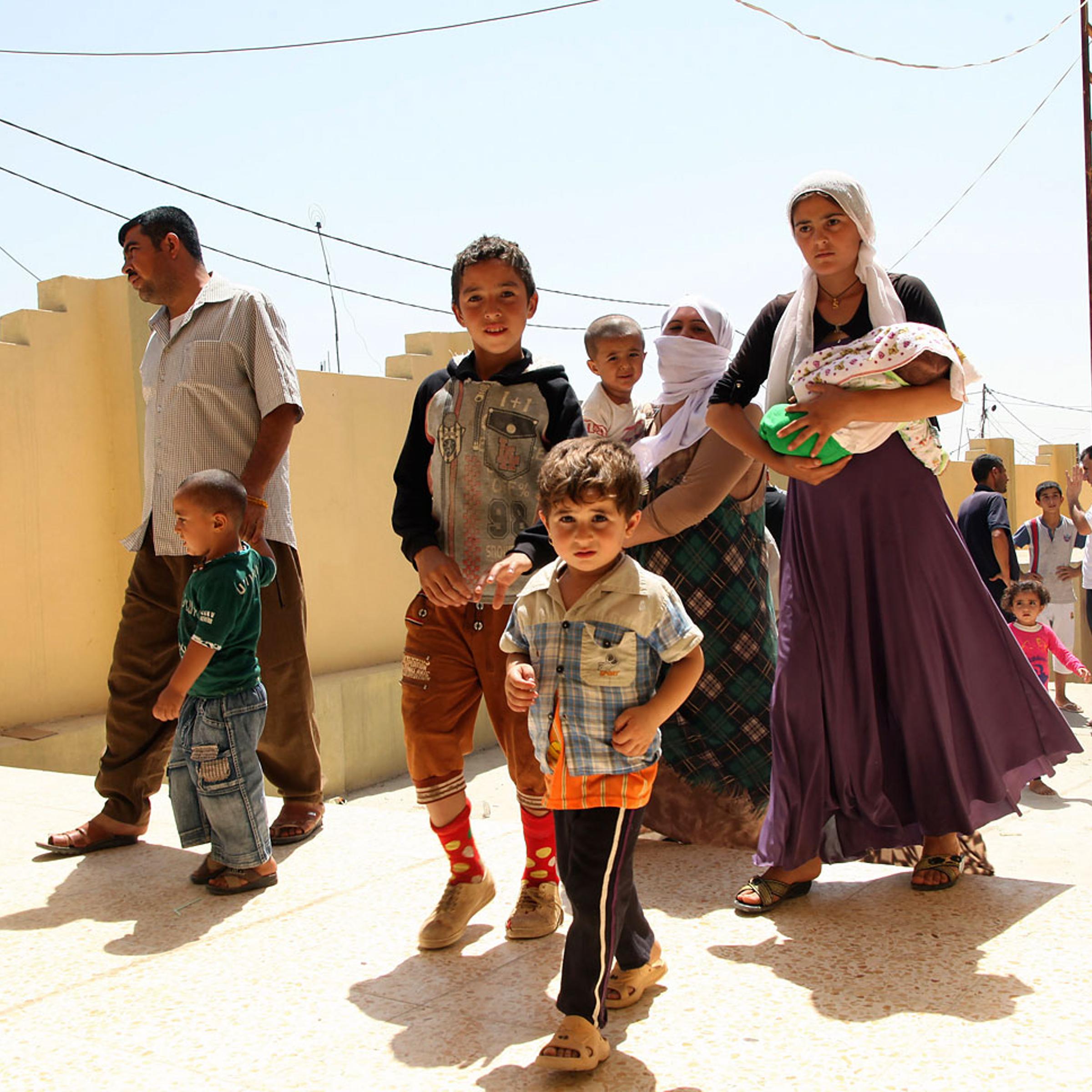 Displaced families from the minority Yazidi sect, fleeing the violence in the Iraqi town of Sinjar west of Mosul, arrive at Dohuk province