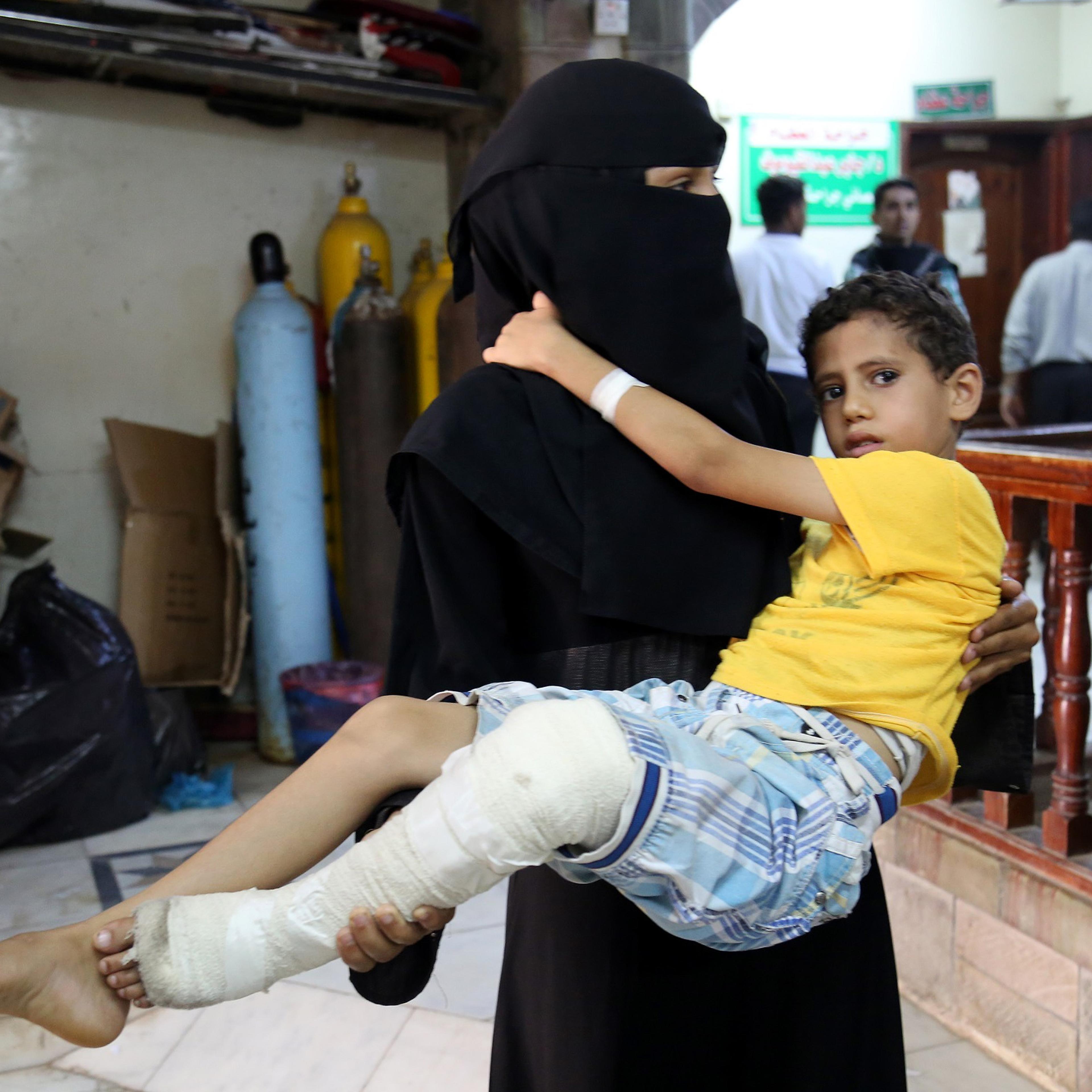 Woman carries a boy, who has been injured in a Shiite Houthi attack targeted residential areas, to es-Sevra hospital, in Taiz, Yemen on June 4, 2016.