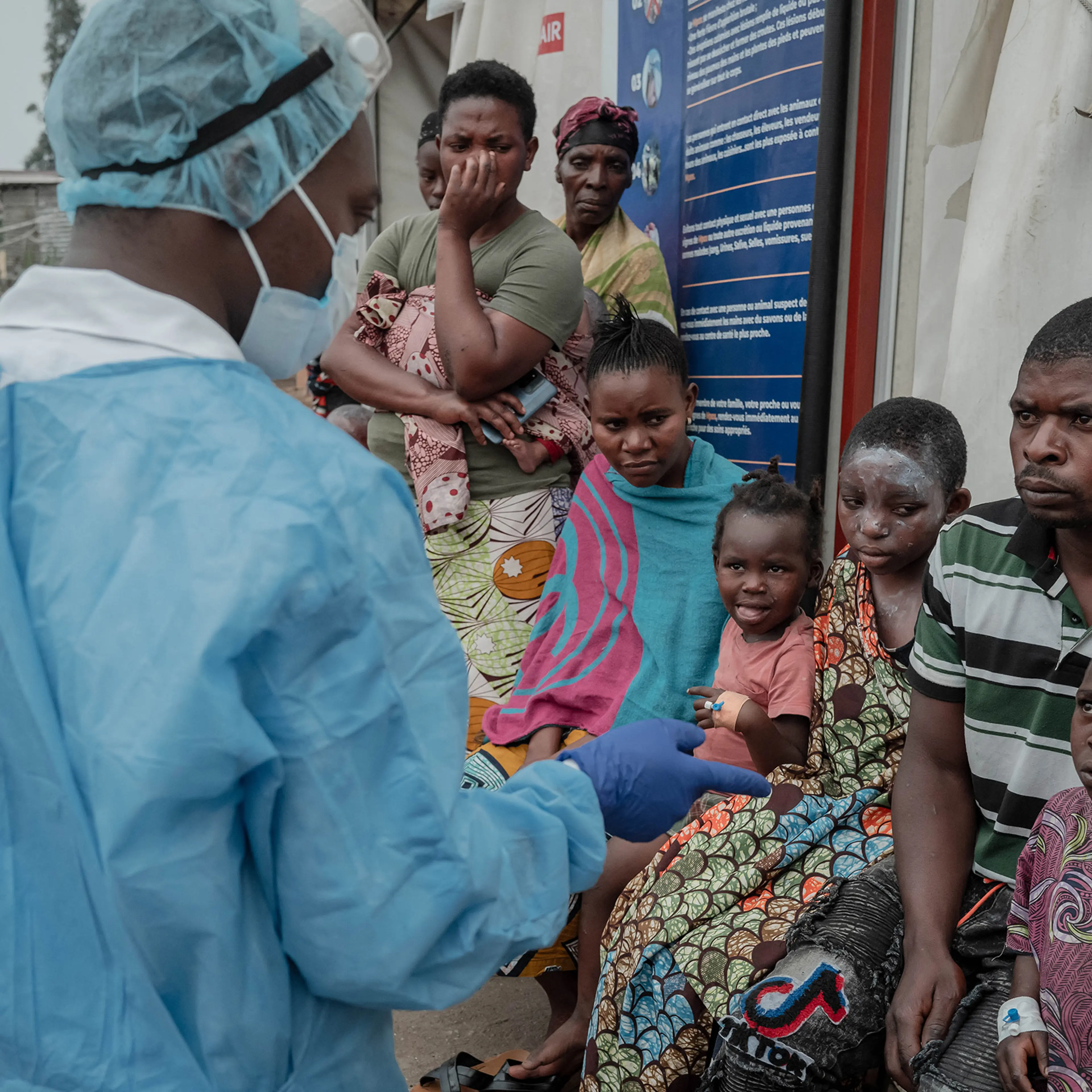 Patients listen to a doctor outside the consultation room of the Mpox treatment centre at Nyiragongo General Referral Hospital, north of Goma on Aug. 17, 2024.