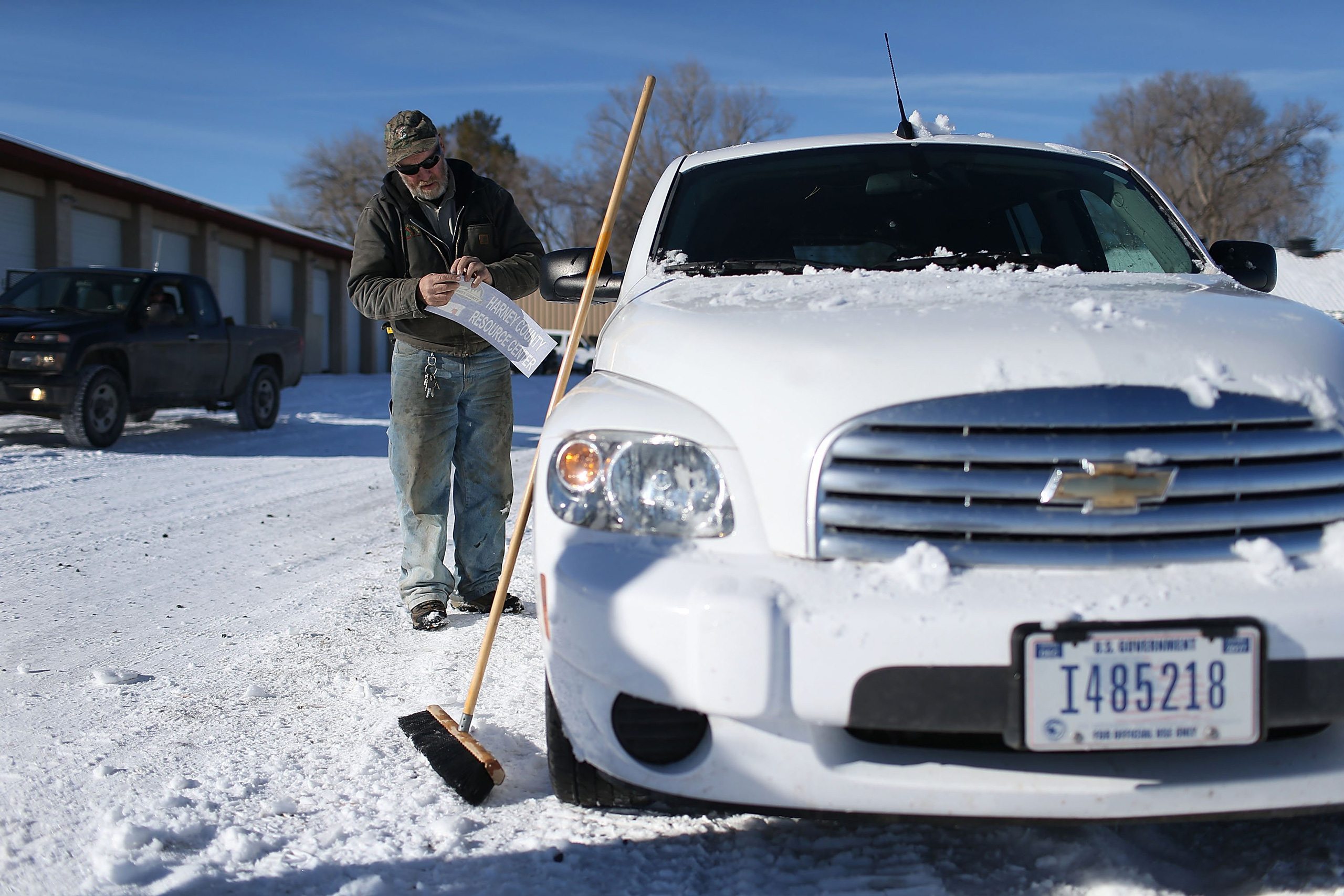 BURNS, OR - JANUARY 15: Ken Medenbach prepares to paste a Harney County sticker on the side of a U.S. Government vehicle as a group continues to occupy the Malheur National Wildlife Refuge headquarters on January 15, 2016 near Burns, Oregon. The armed an