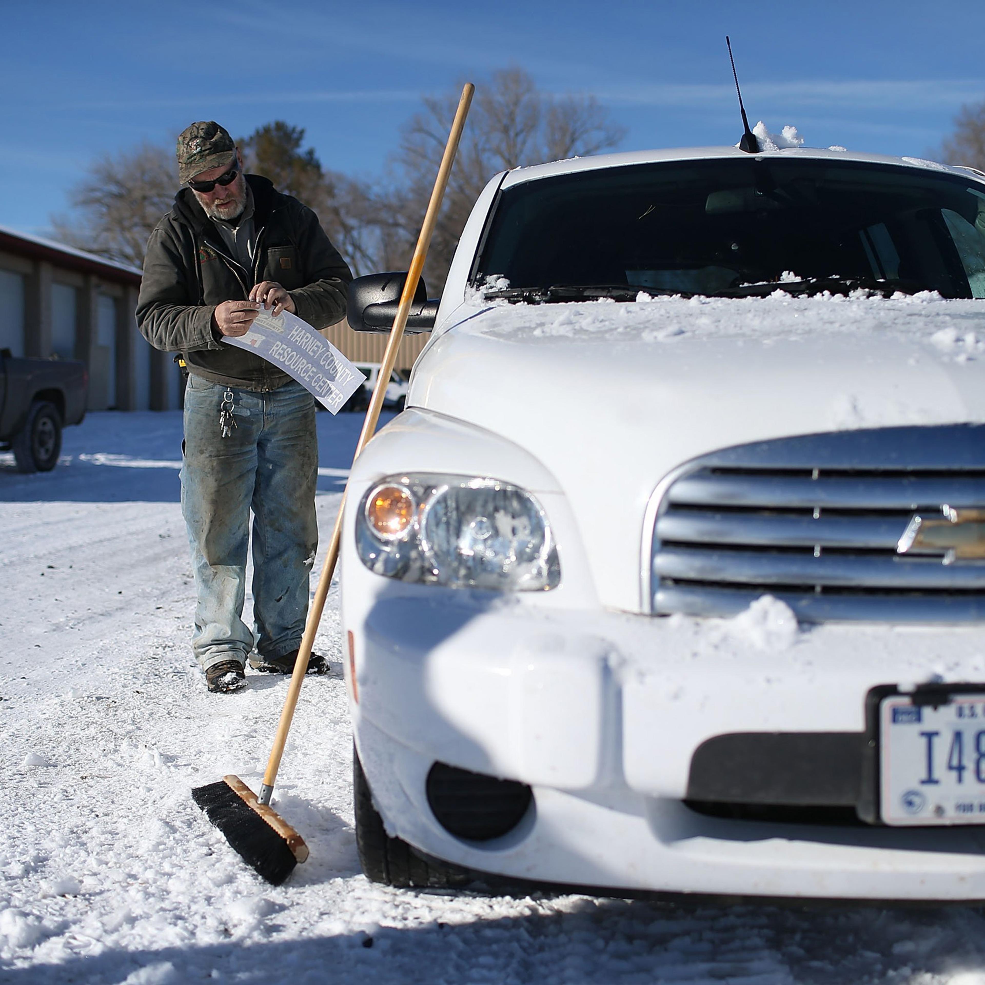 BURNS, OR - JANUARY 15: Ken Medenbach prepares to paste a Harney County sticker on the side of a U.S. Government vehicle as a group continues to occupy the Malheur National Wildlife Refuge headquarters on January 15, 2016 near Burns, Oregon. The armed an