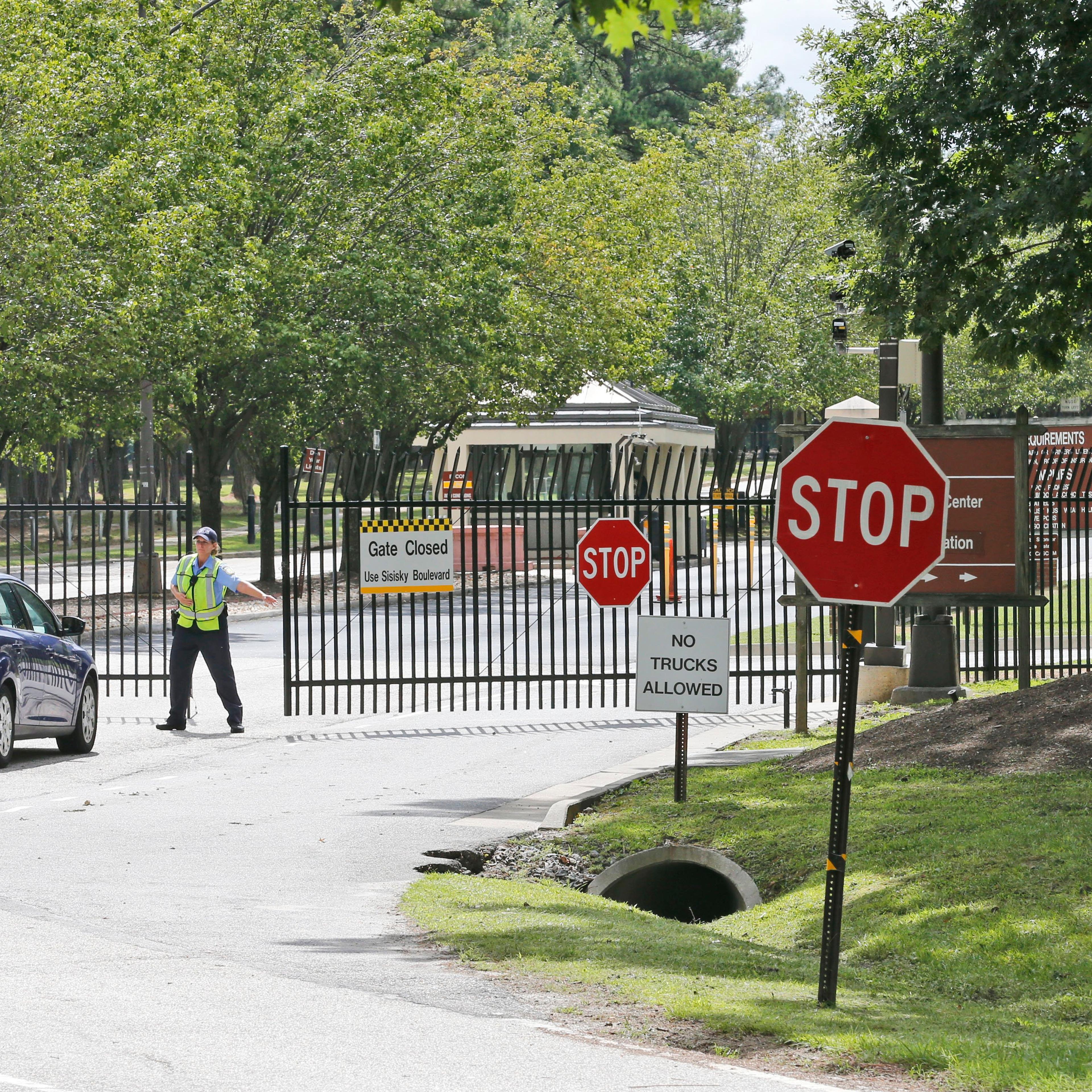 Security guards open a gate for motorist at the visitor entrance to Fort Lee, Va. on Aug. 25, 2014.