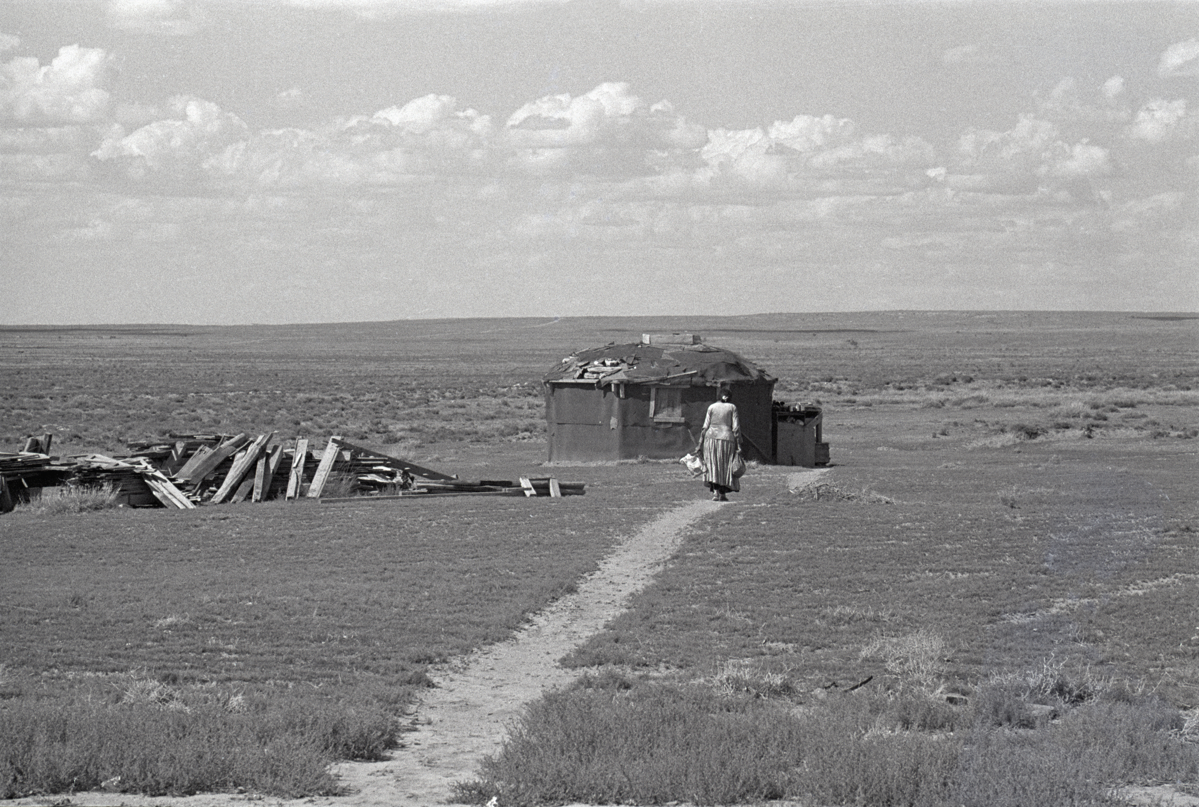 Navajo Woman Walking Towards Hogan